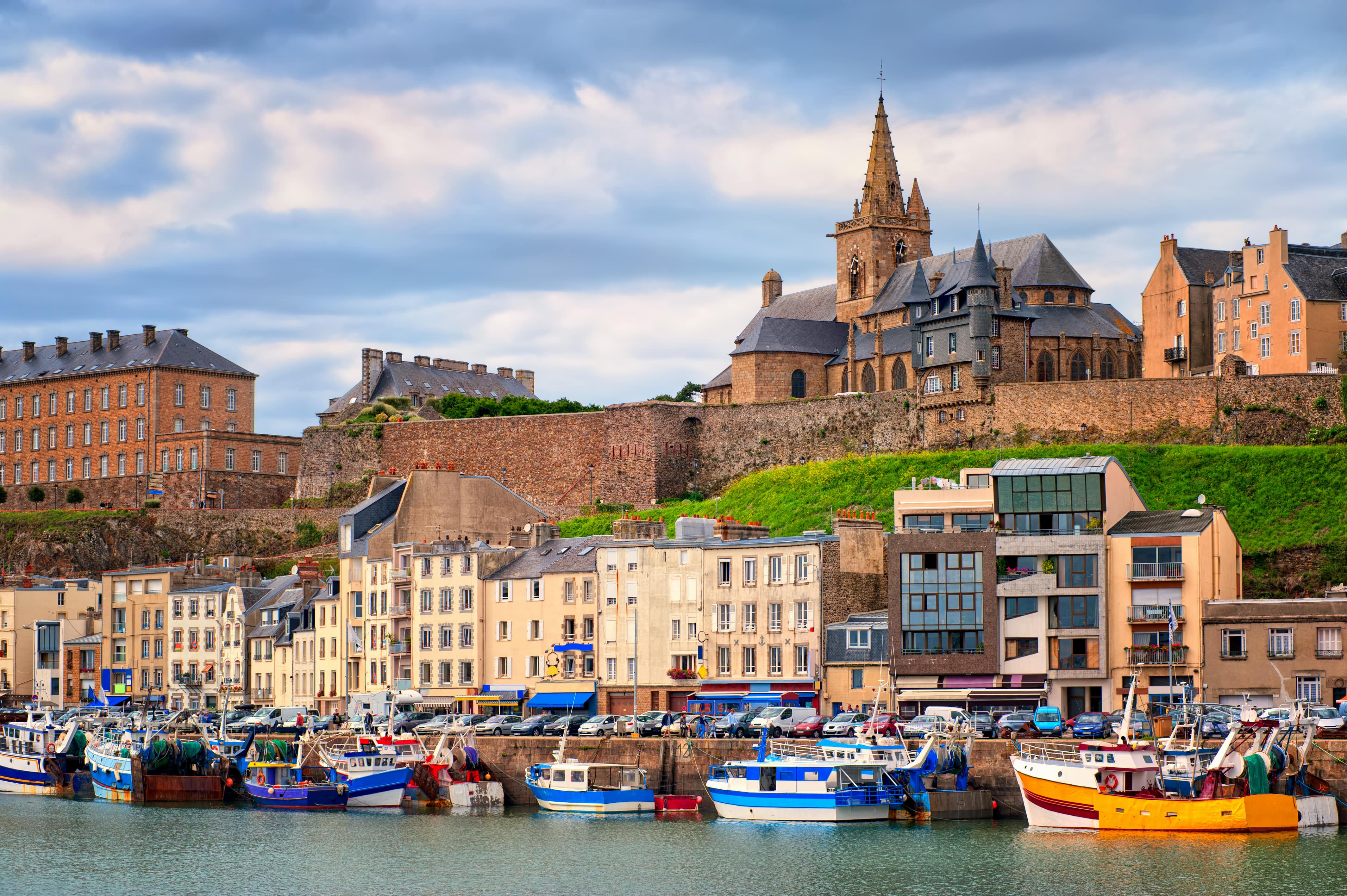Bateaux de pêcheurs à quai devant la ville et la colline où se dresse l’église gothique Notre-Dame de Granville