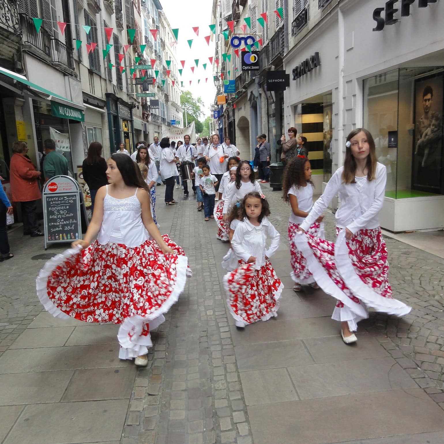Petites filles défilant dans les rue en tenue blanches et rouges. Fêtes traditionnelles et folkloriques au Pays Basque