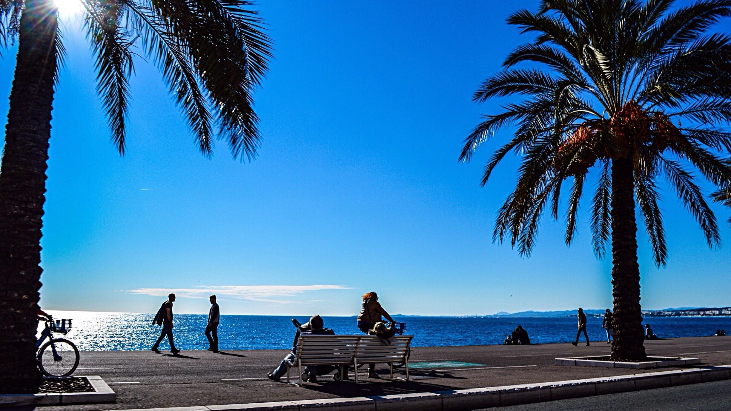 Vélos et passants sur la promenade des Anglais à Nice