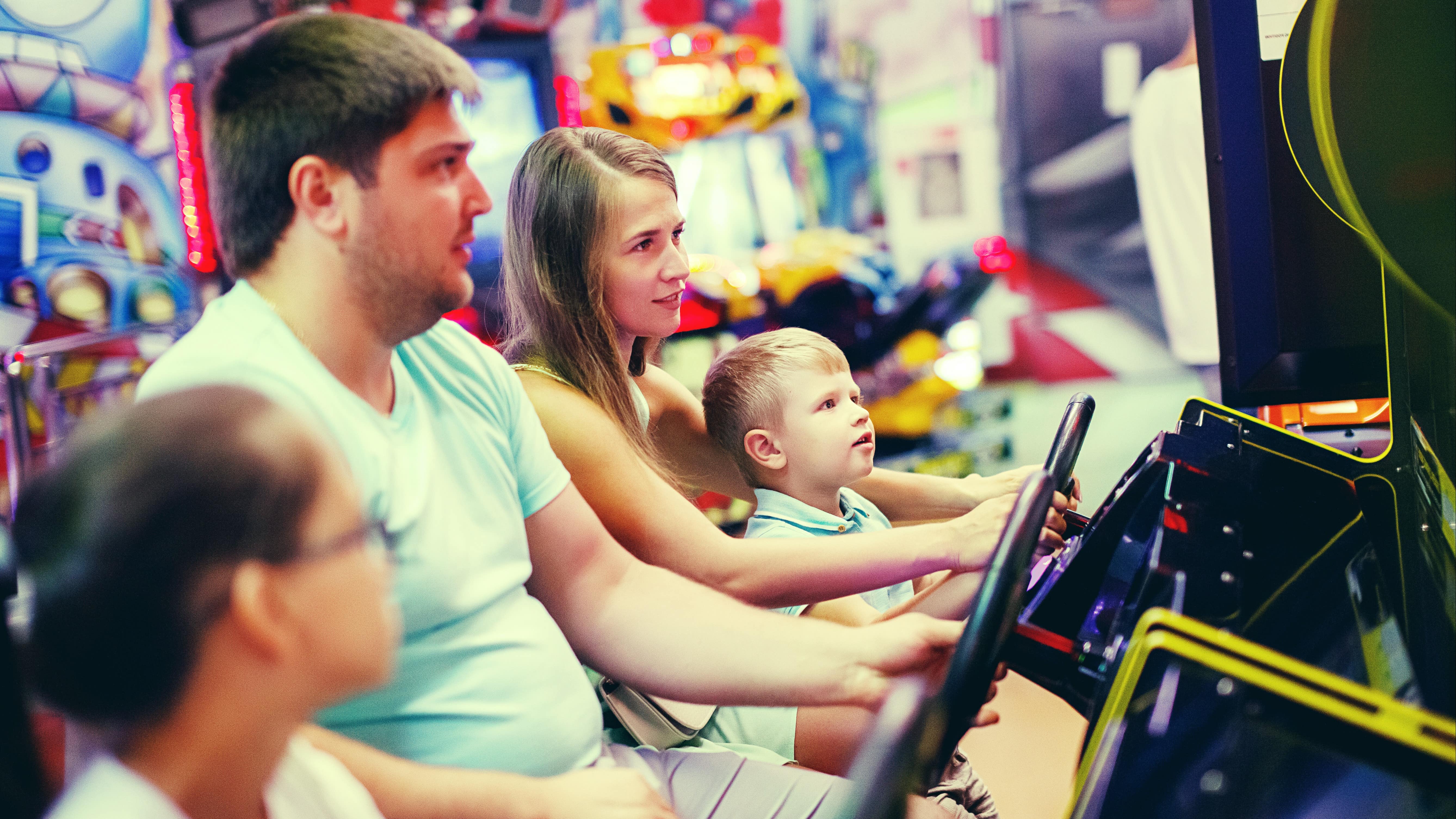 Une famille qui joue à des jeux d’arcade