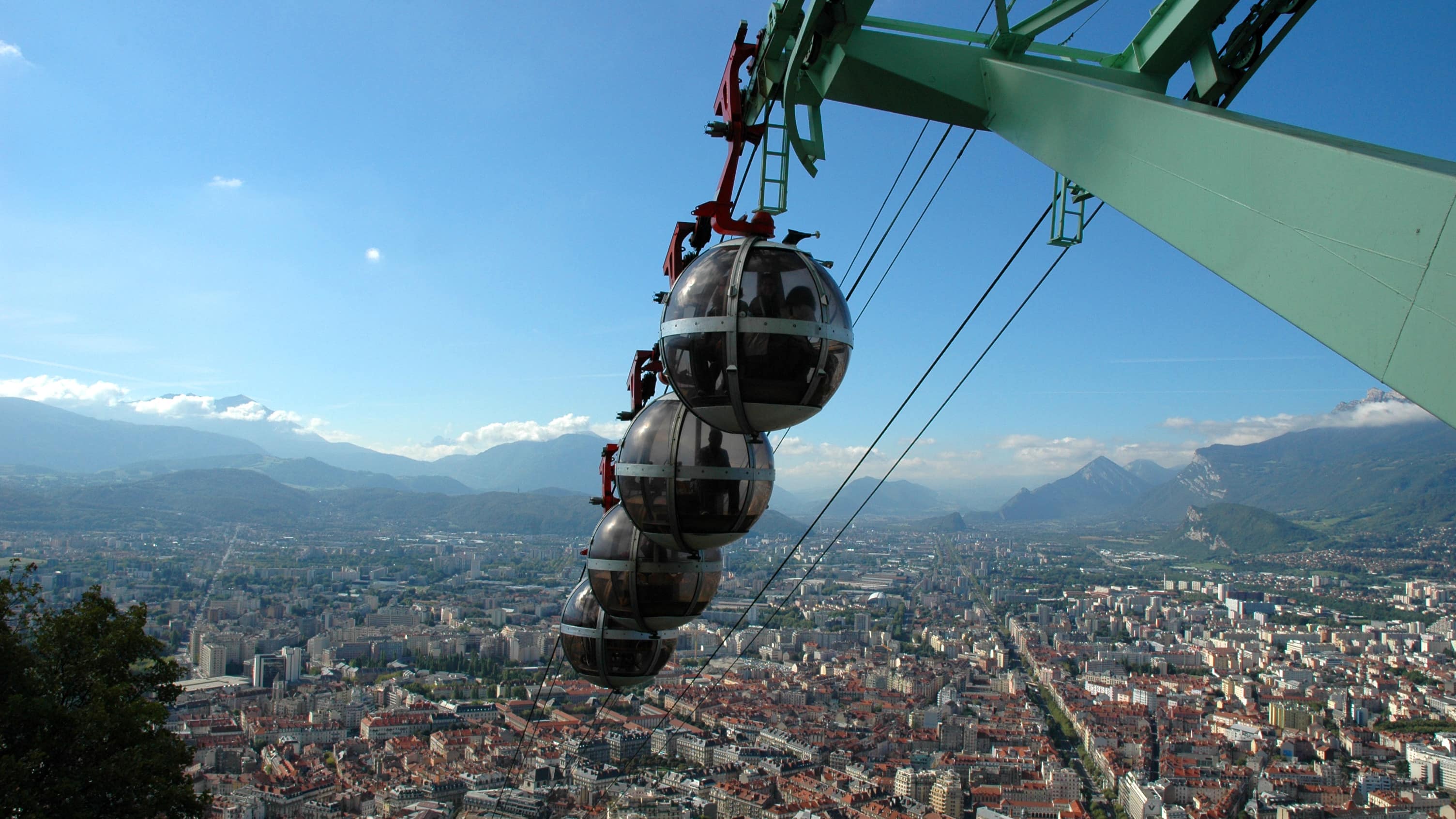 « Bulles » du téléphérique Grenoble Bastille et vue sur la ville de Grenoble en contrebas et les montagnes au loin
