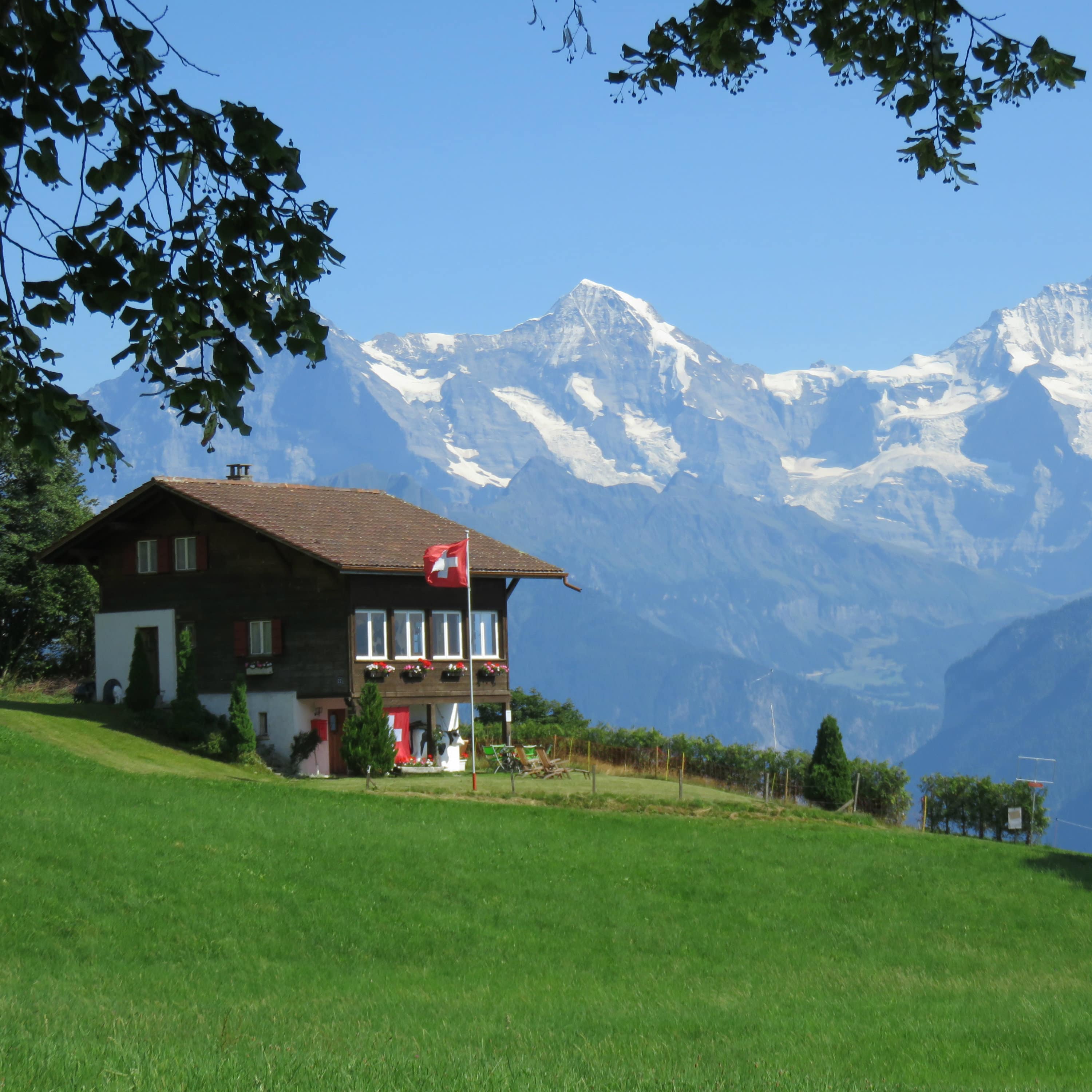 Un chalet en bois suisse sur fond de montagnes enneigées