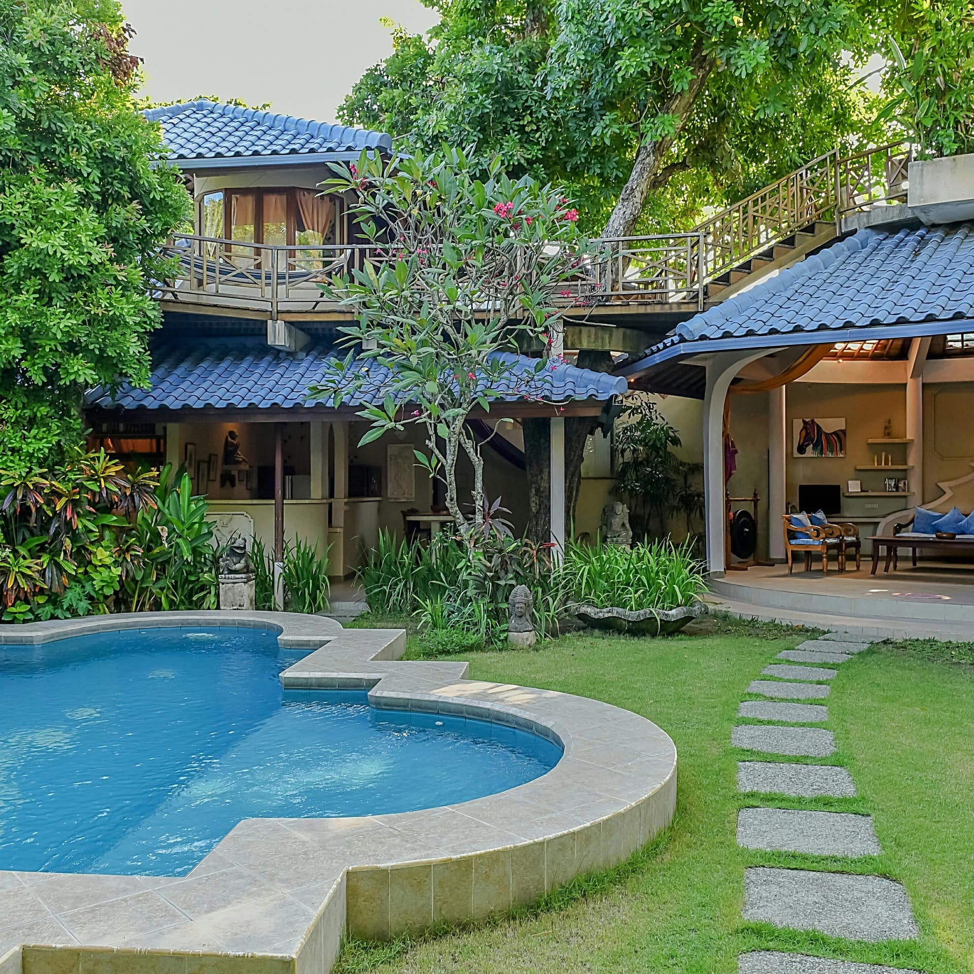 A luxury Bali villa with a seating area and pool in the garden