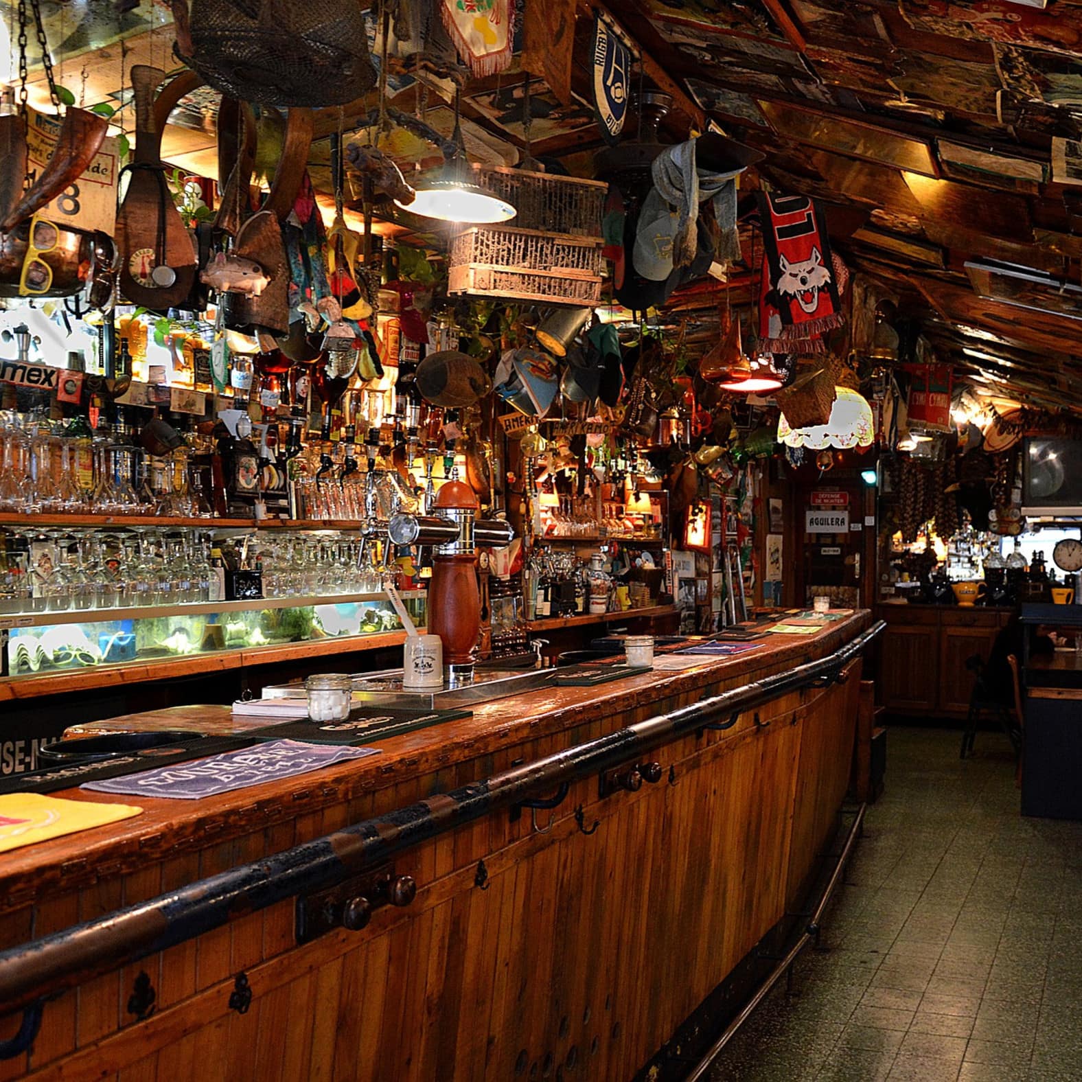 Ancien bar en bois, chargé de verres et de décoration, au cœur du Pas Basque