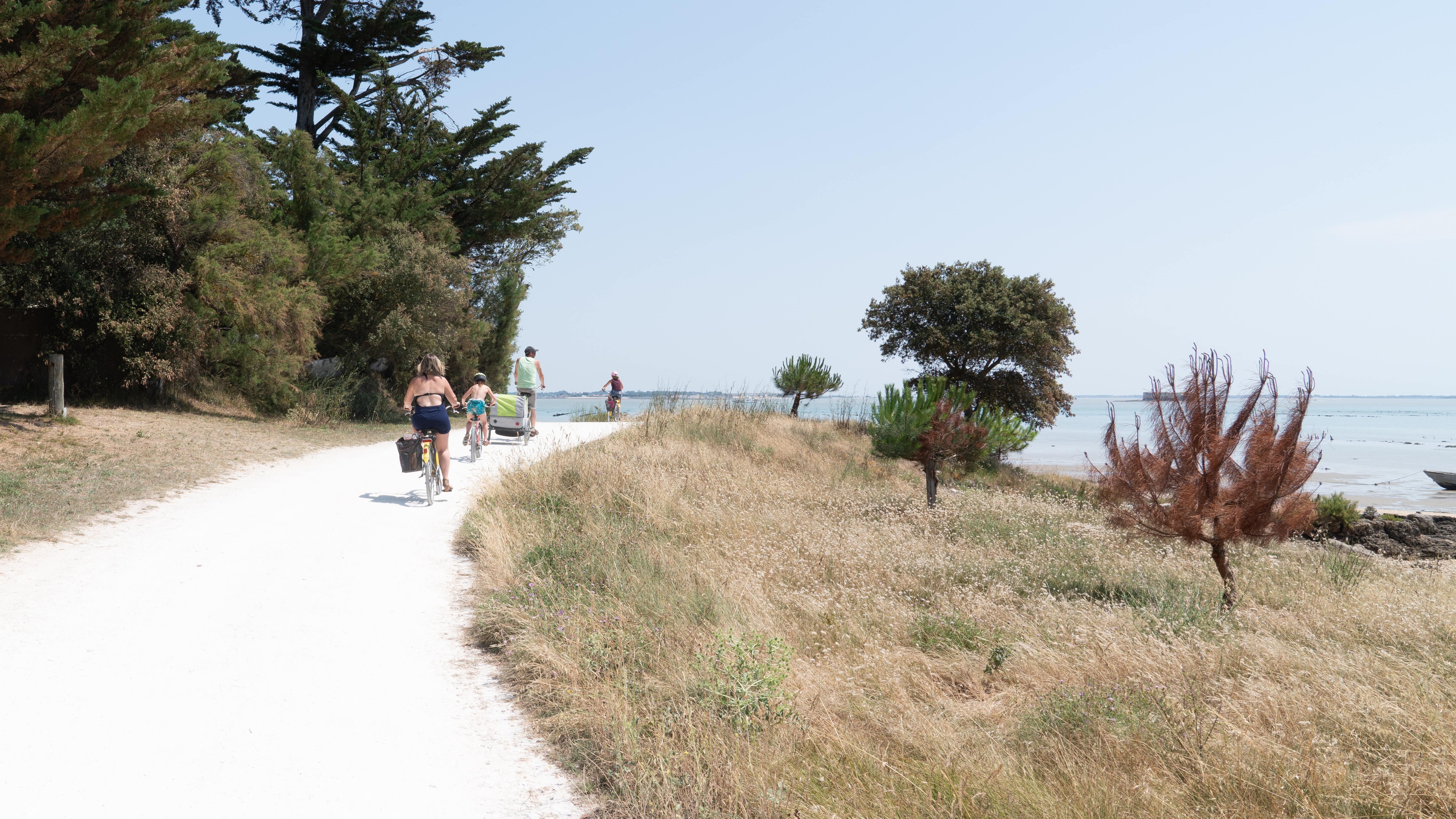 Une famille à vélo sur un chemin côtier de l’île d’Aix