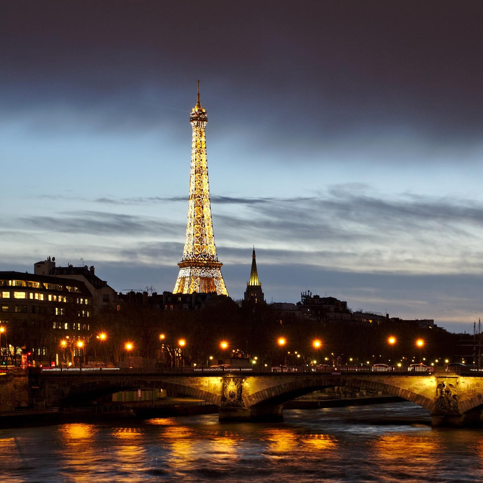 Vue sur la tour Eiffel et un des ponts de Paris de nuit