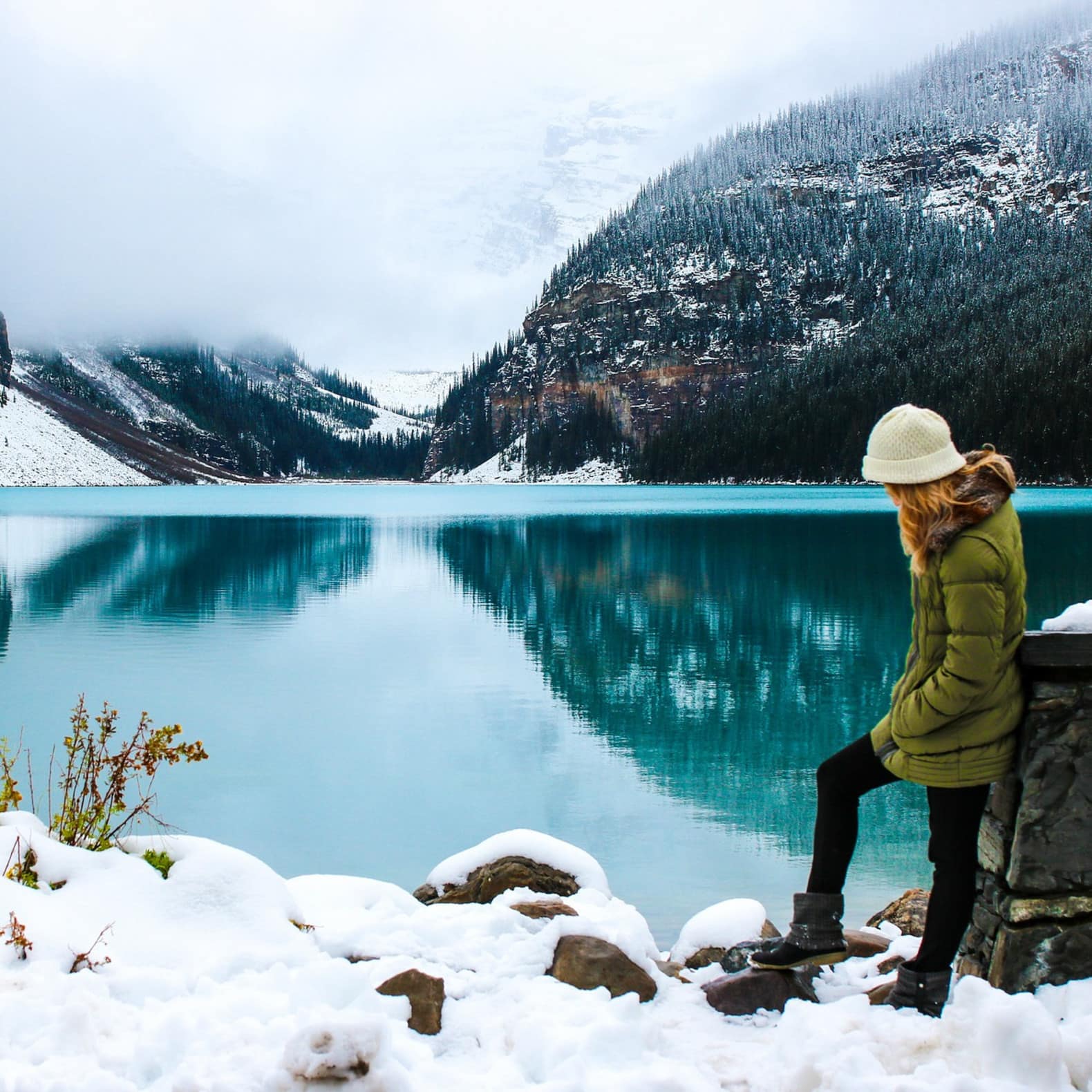 Femme devant un lac face aux montagnes