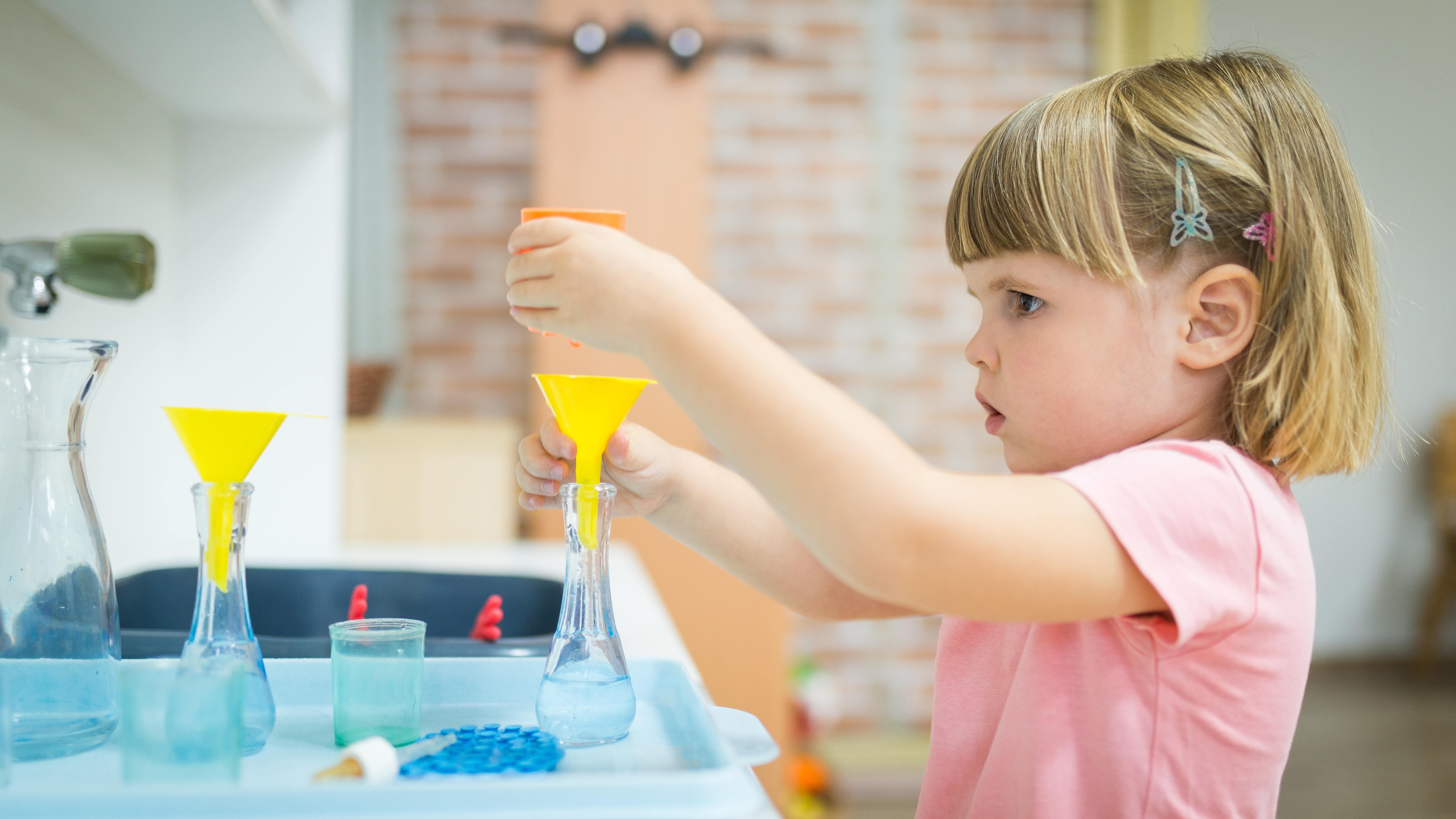 Une petite fille se livrant à une expérience scientifique avec des erlenmeyers