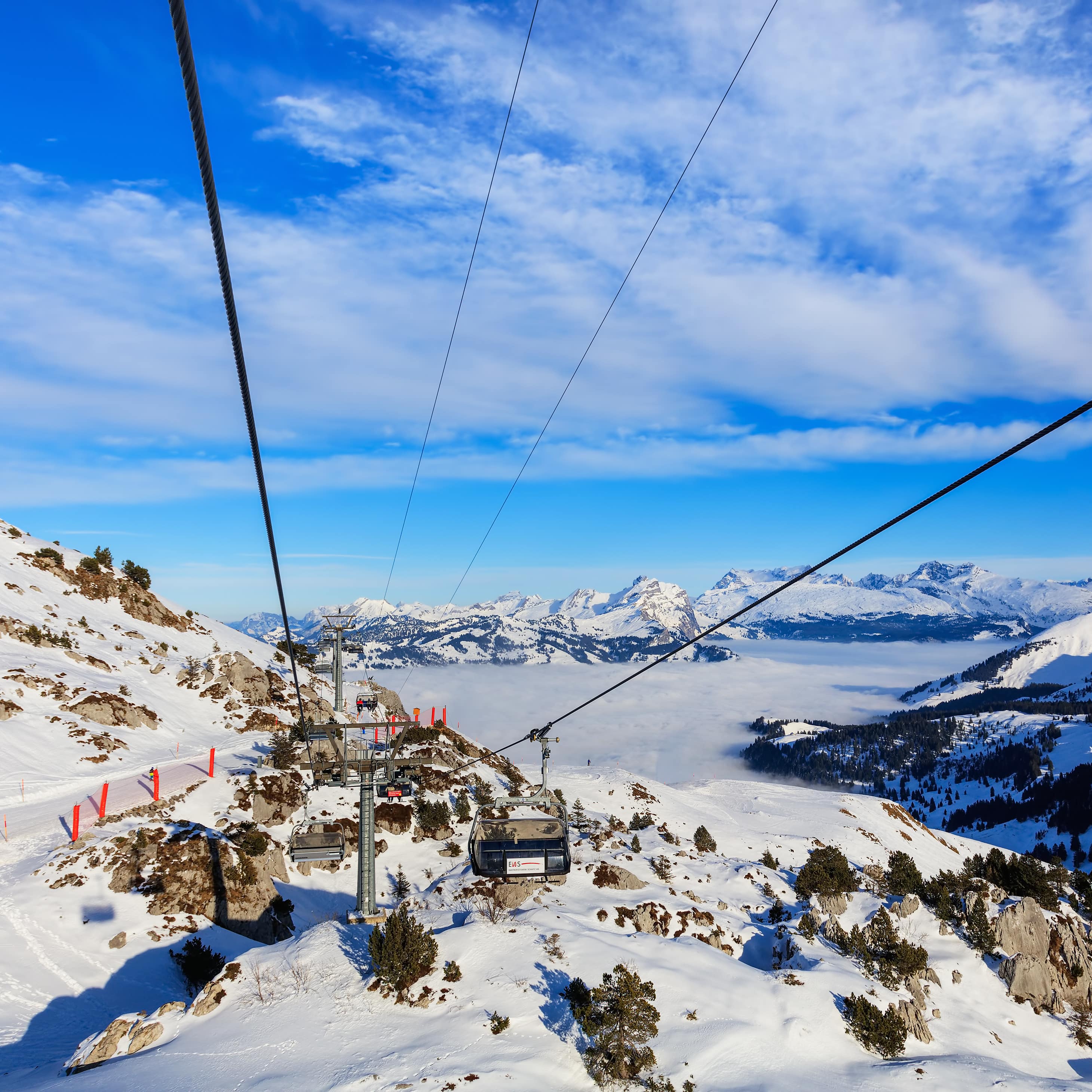 Des télésièges traversent les montagnes des Alpes dans un paysage de montagnes enneigées