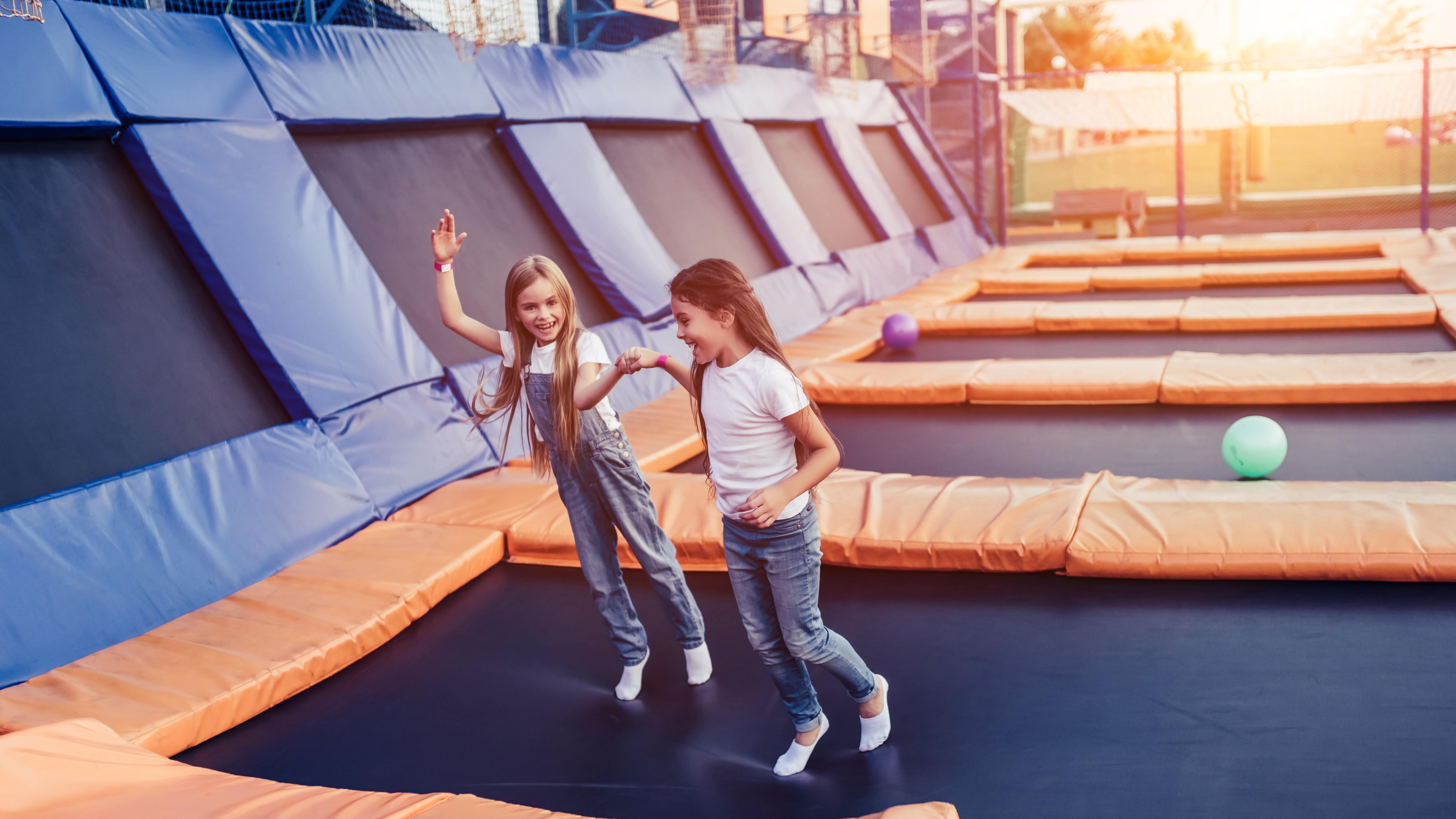 Vue sur deux petites filles jouant dans un parc à trampolines