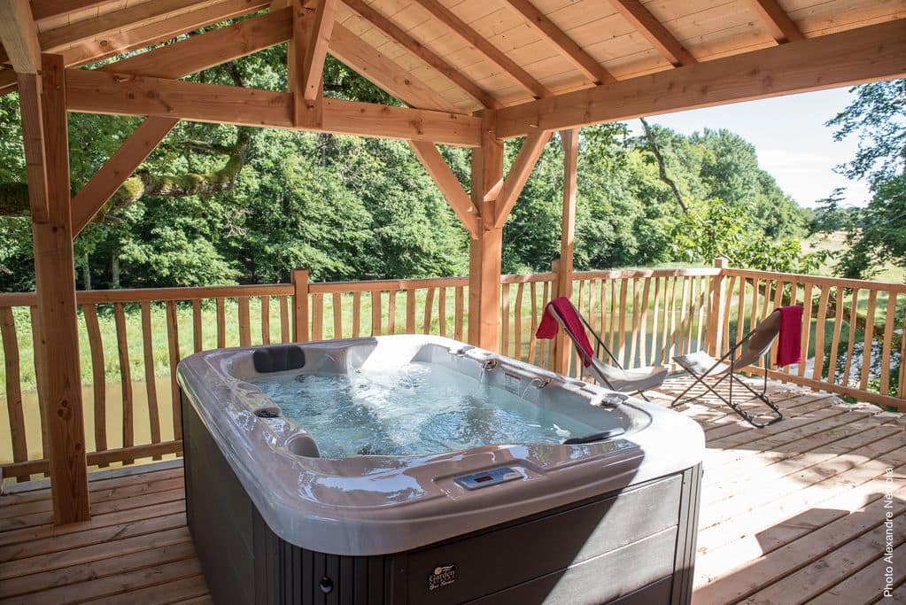 Jacuzzi dans cabane de luxe avec vue sur la forêt