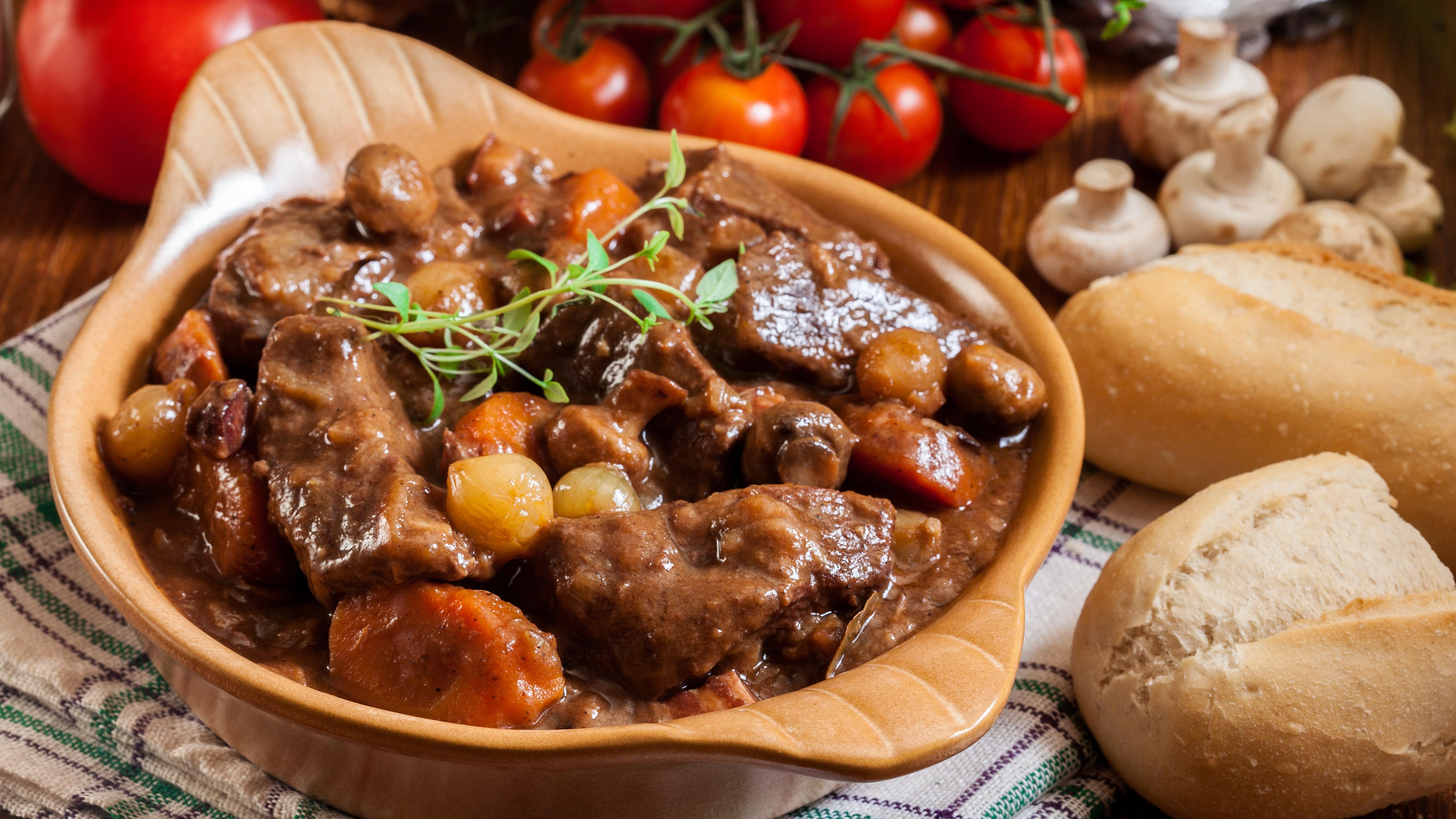 Vue sur un plat contenant du bœuf bourguignon, accompagné de pain