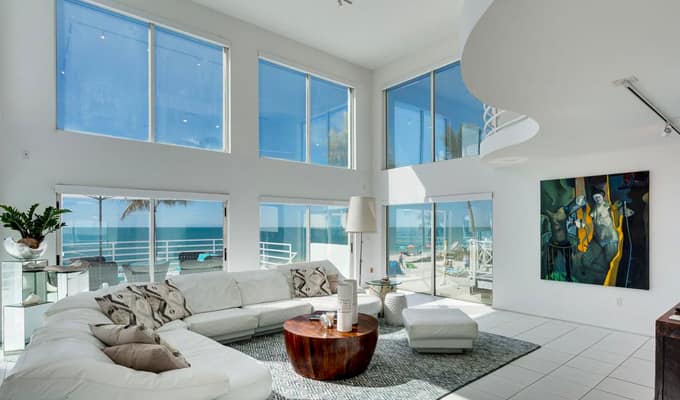 big white house by the beach with large windows