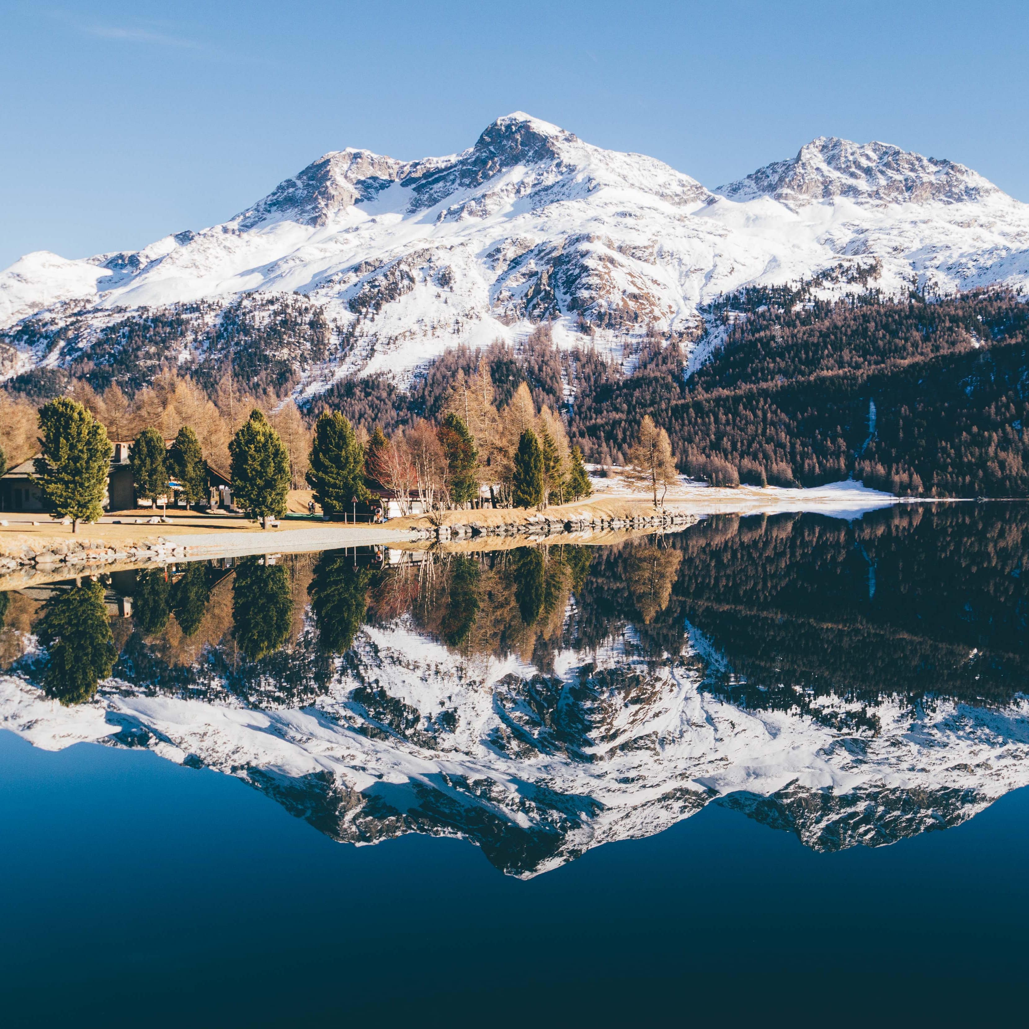 Un lac glaciaire dans lequel les sommets enneigés des montagnes se reflètent