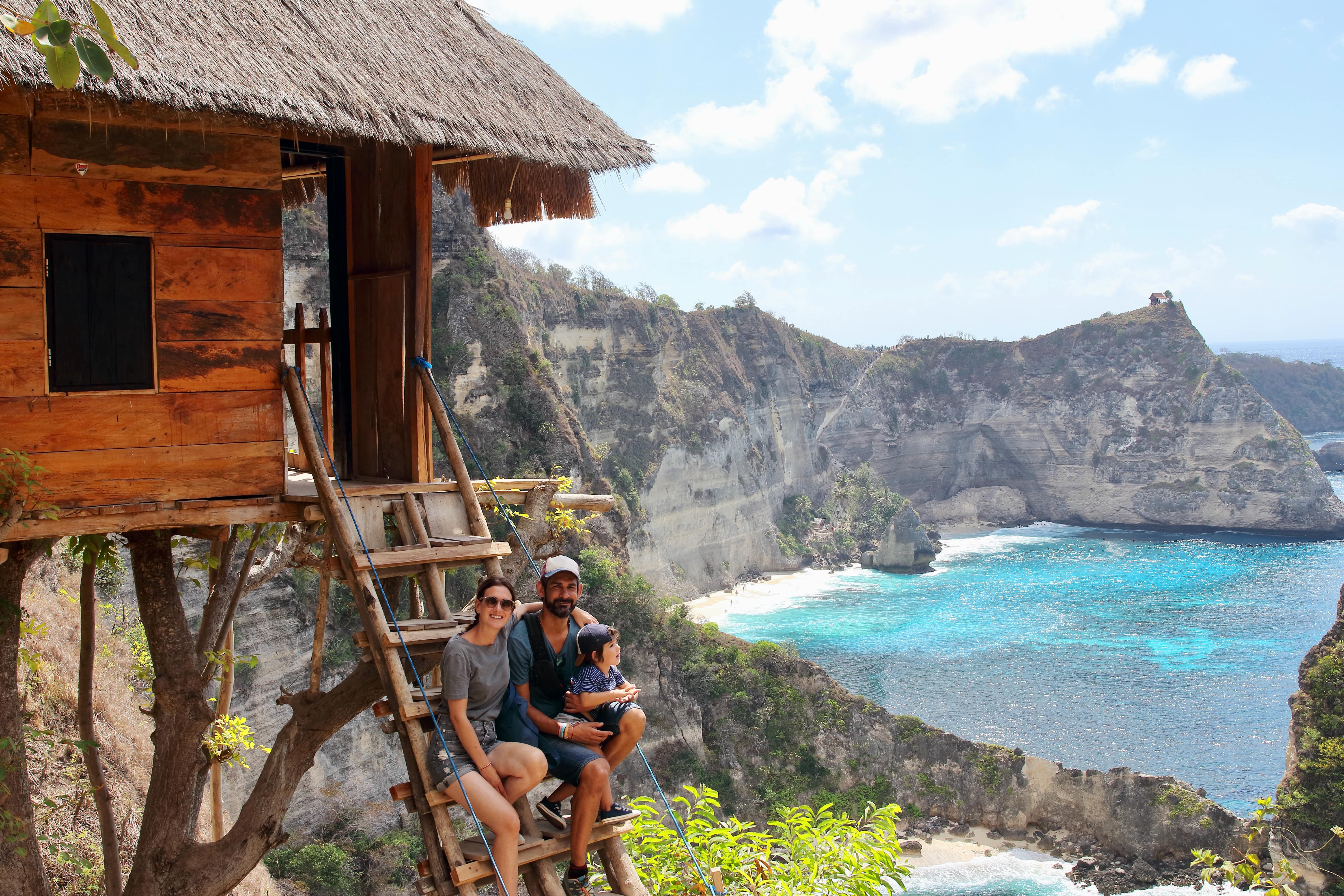 Parents et petit enfant profitant de la vue depuis les escaliers en bois de l'une des célèbres cabanes dans les arbres du point de vue des Mille-Îles, sur l'un des endroits les plus étonnants de l'île de Nusa Penida, Indonésie, Bali.