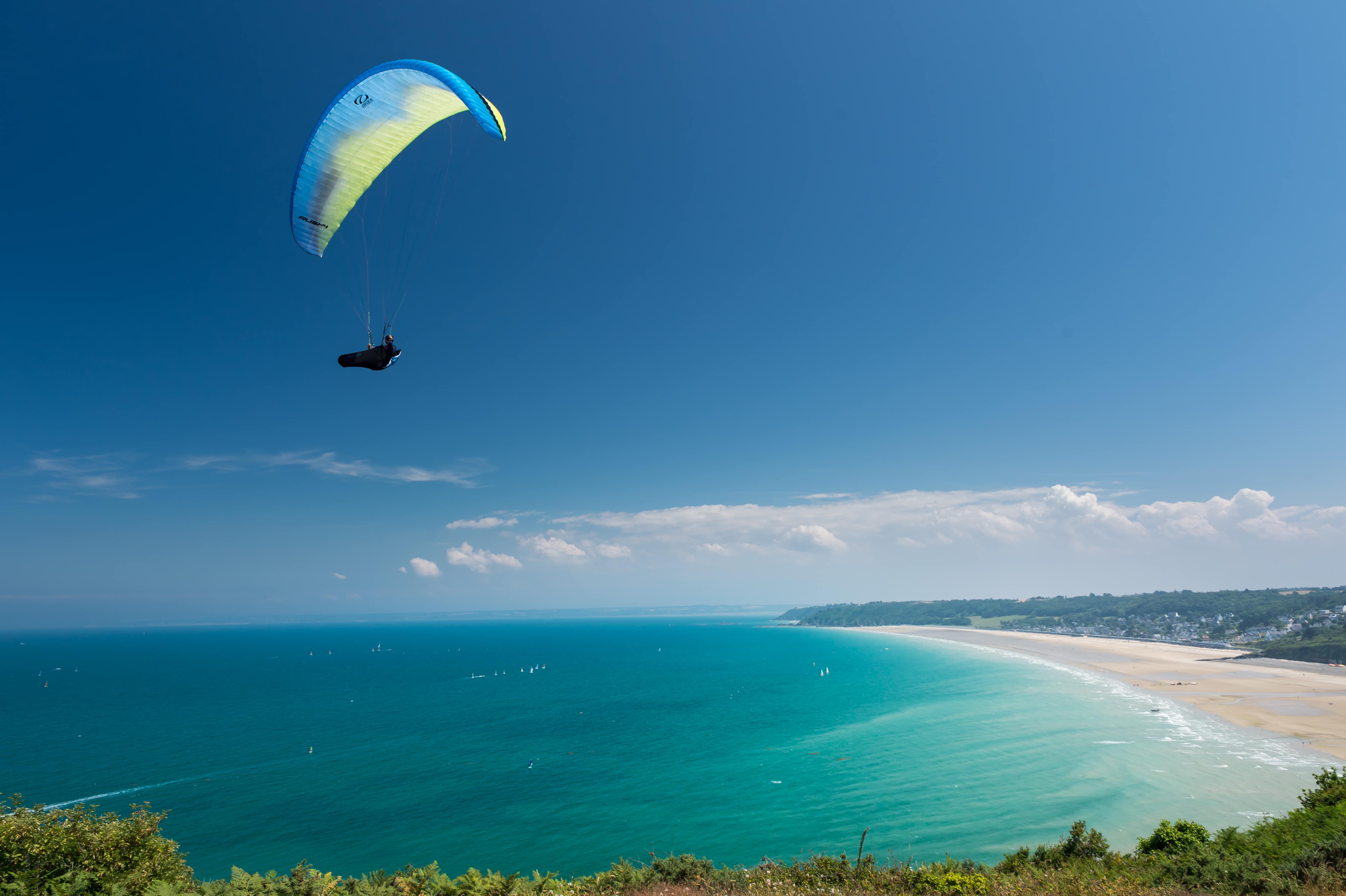 Vue sur un parapente au-dessus d'une mer bleu turquoise