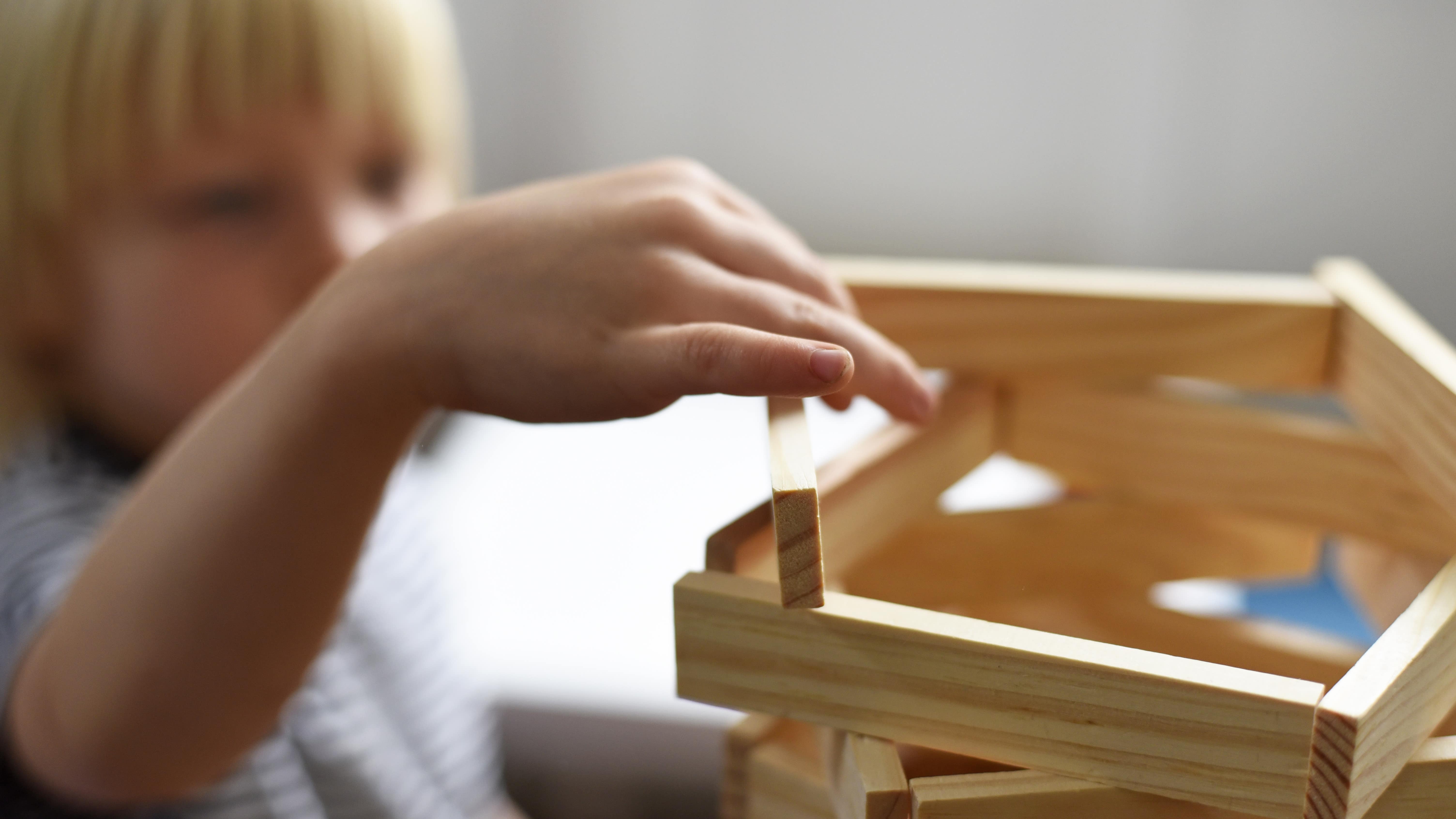Enfant construisant une tour en planchettes Kapla