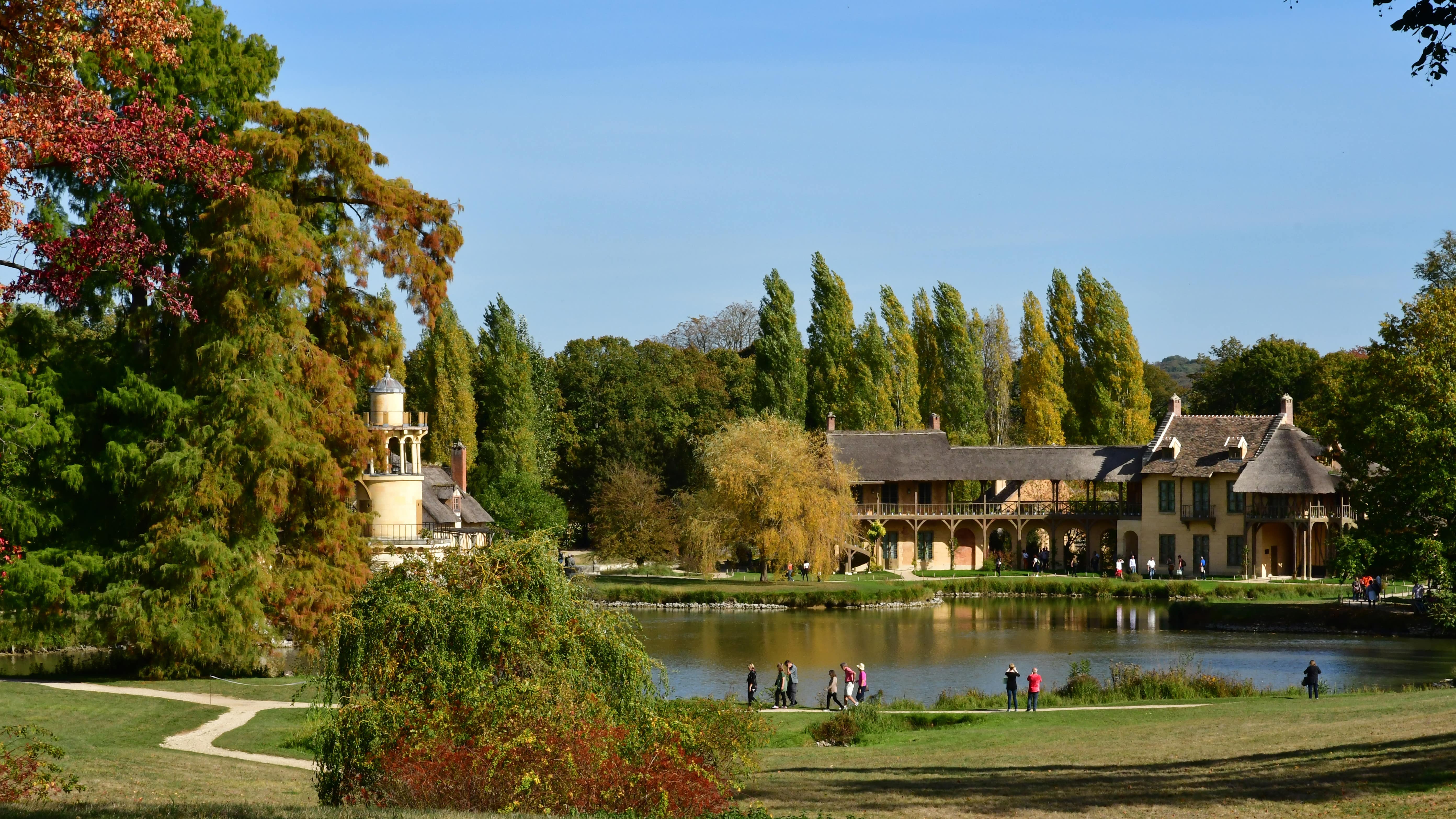 Des familles en promenade autour de l’étang du hameau de la Reine au château de Versailles