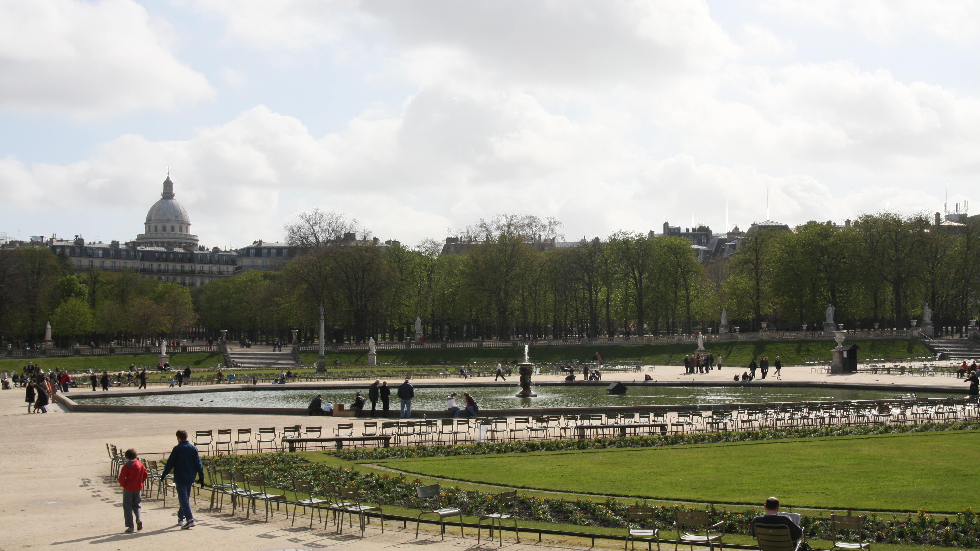 Promeneurs autour du bassin et des pelouses du jardin du Luxembourg à Paris