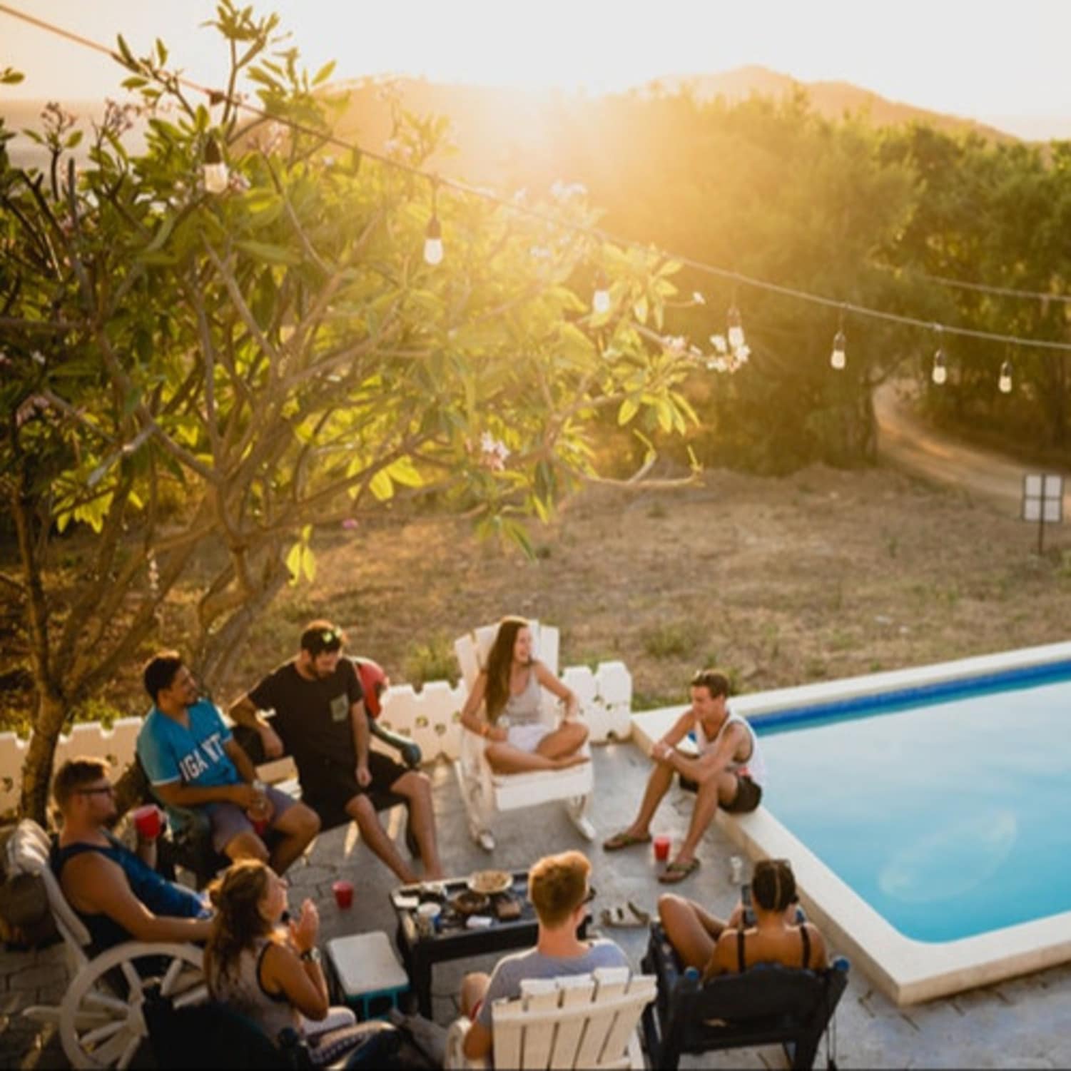 Groupe d’amis à côté d’une piscine, soleil couchant, villa ile Maurice