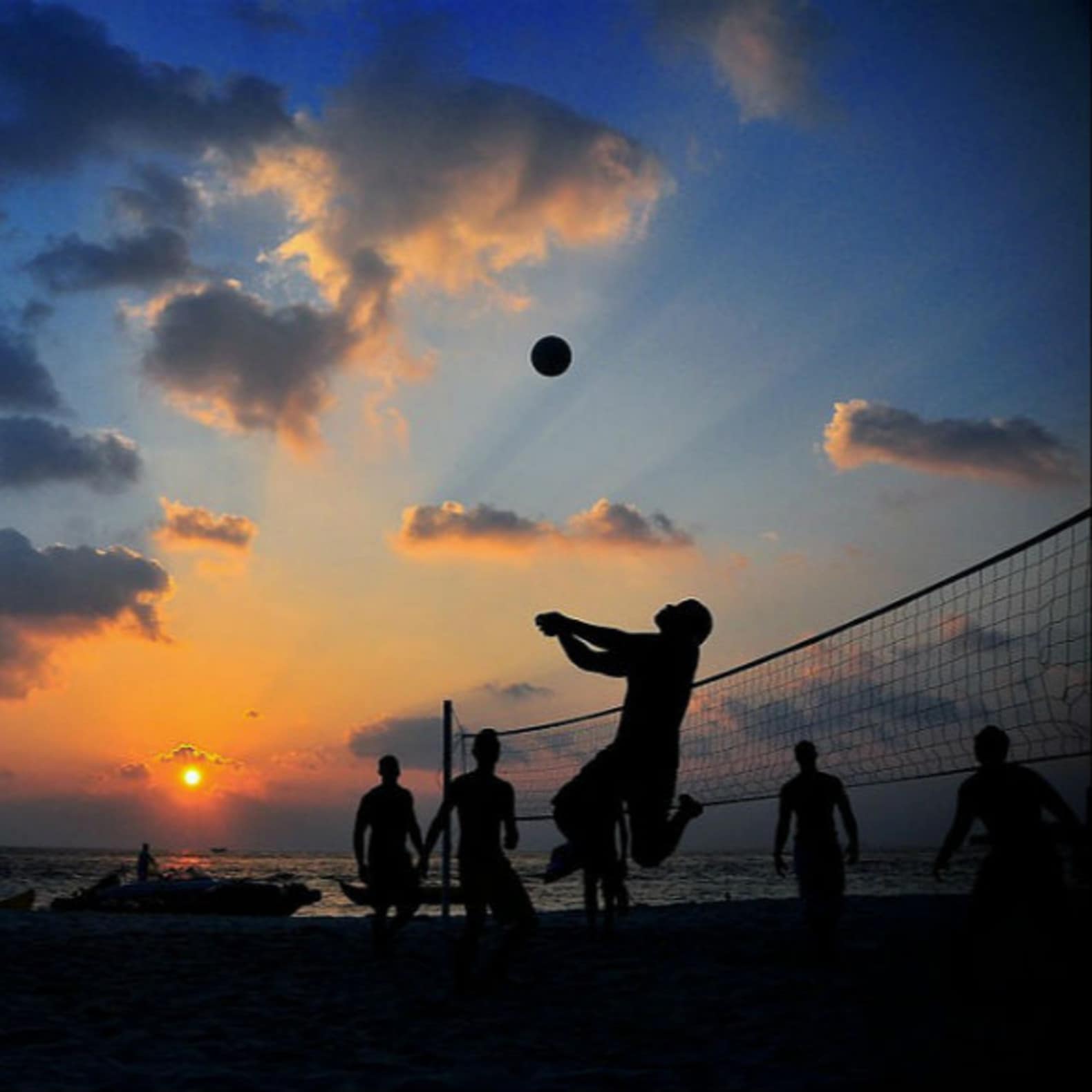 Groupe d’amis jouant au beach-volley sur la plage au soleil couchant, location Narbonne plage