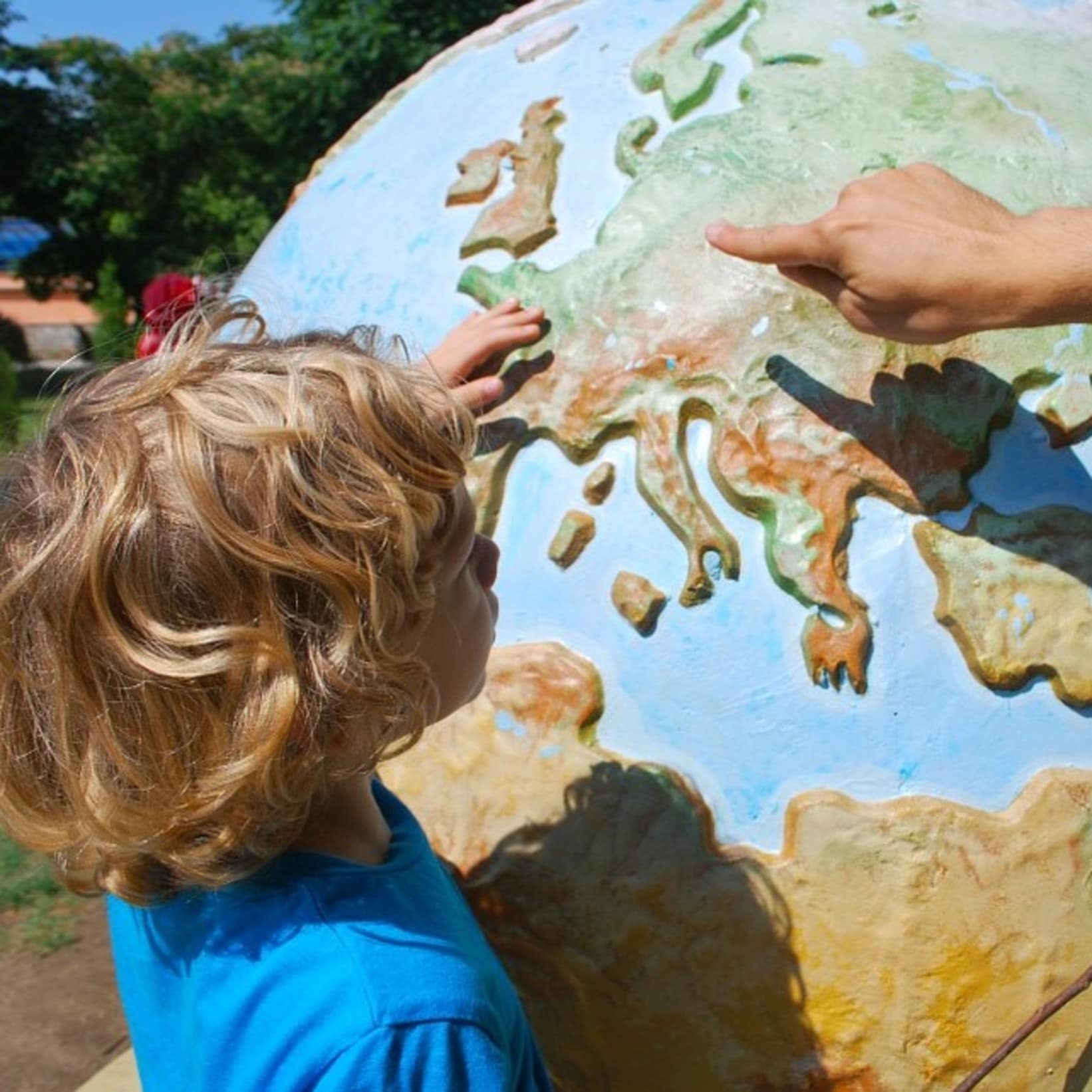 Enfant regardant une mappemonde, vacances avec enfants