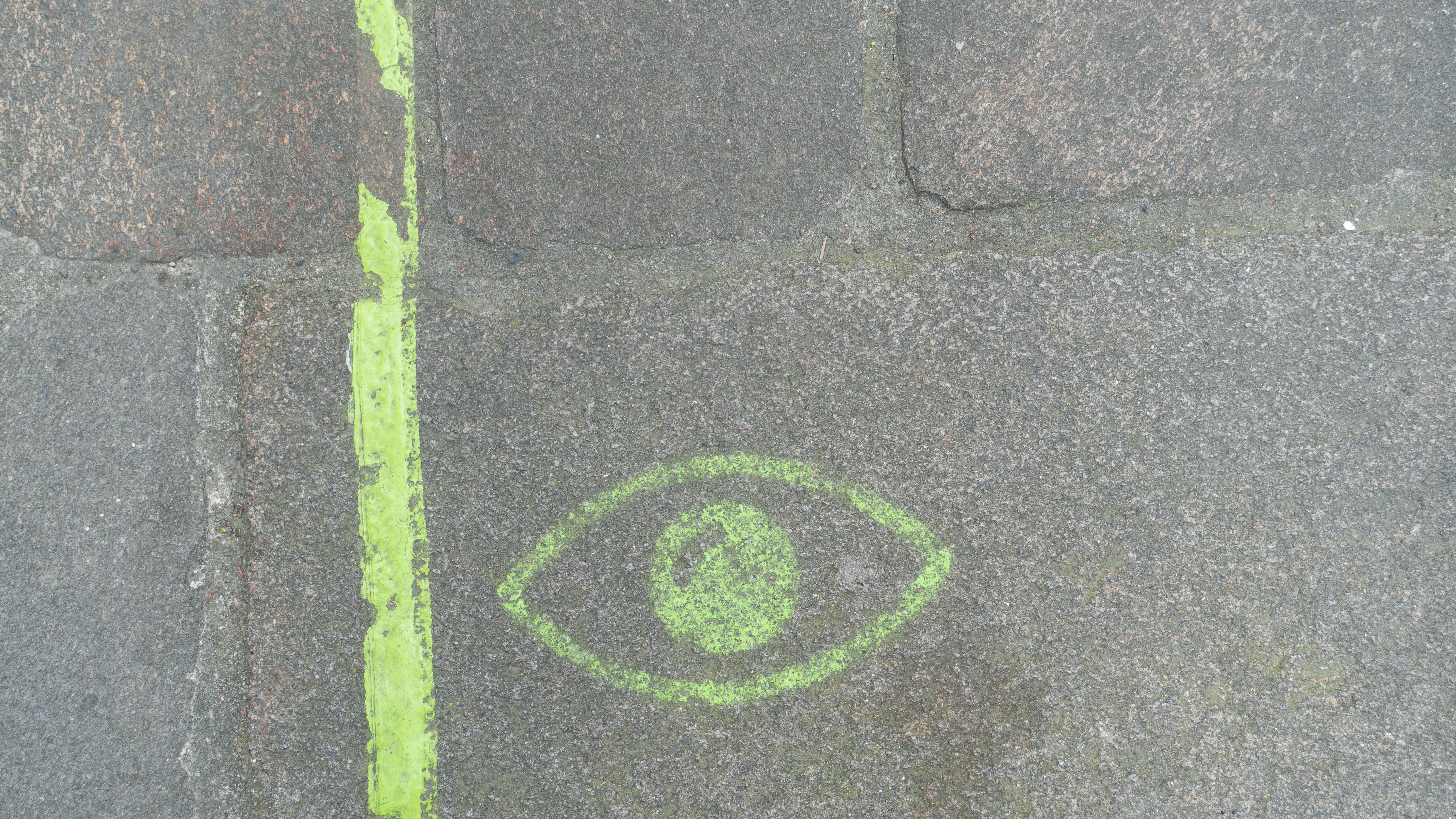 Marque verte sur le sol d’une rue pavée pour guider les visiteurs sur le parcours « Voyage à Nantes »