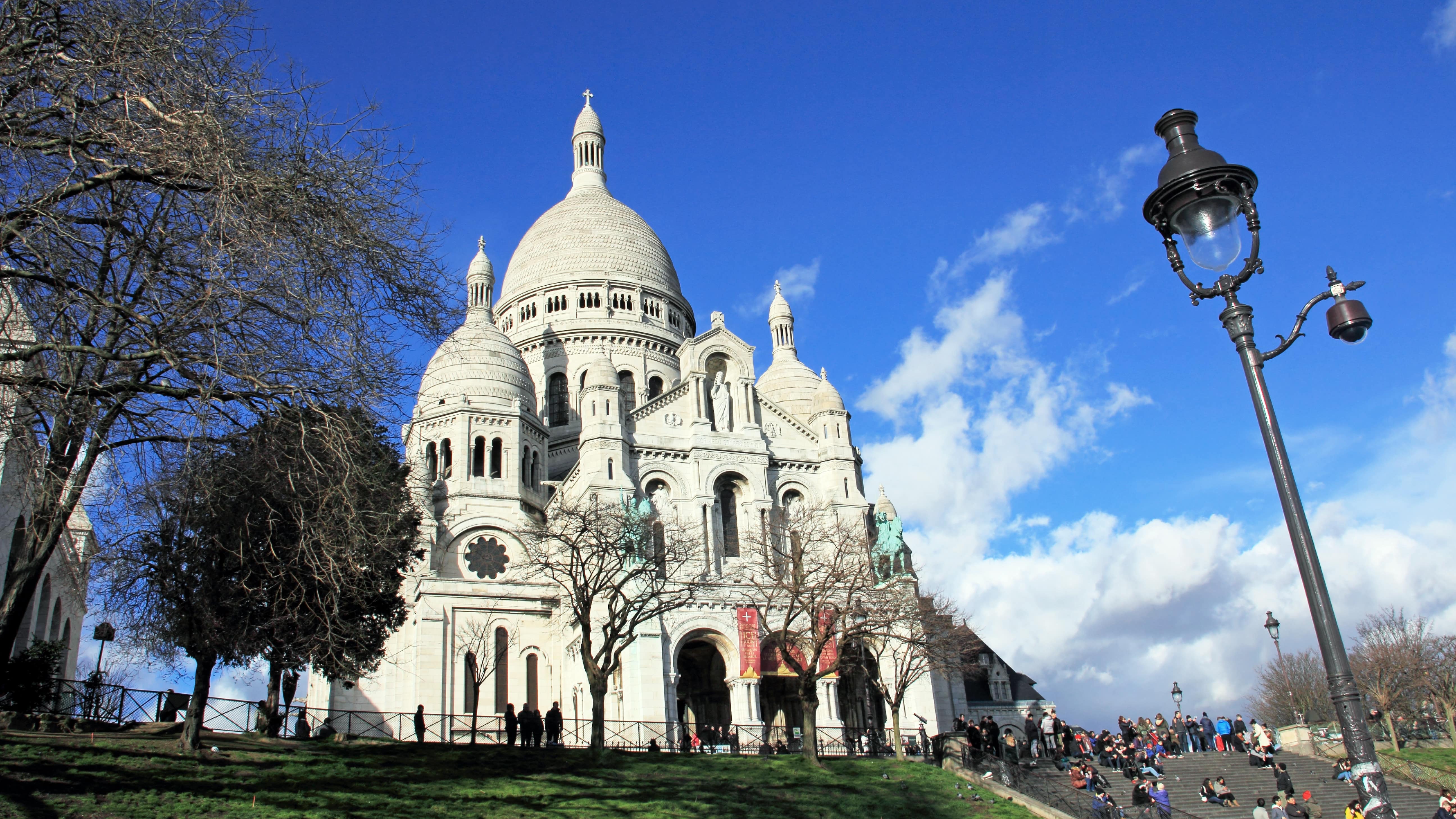 Vue sur le Sacré-Cœur avec un lampadaire ouvragé au premier plan, butte Montmartre, Paris