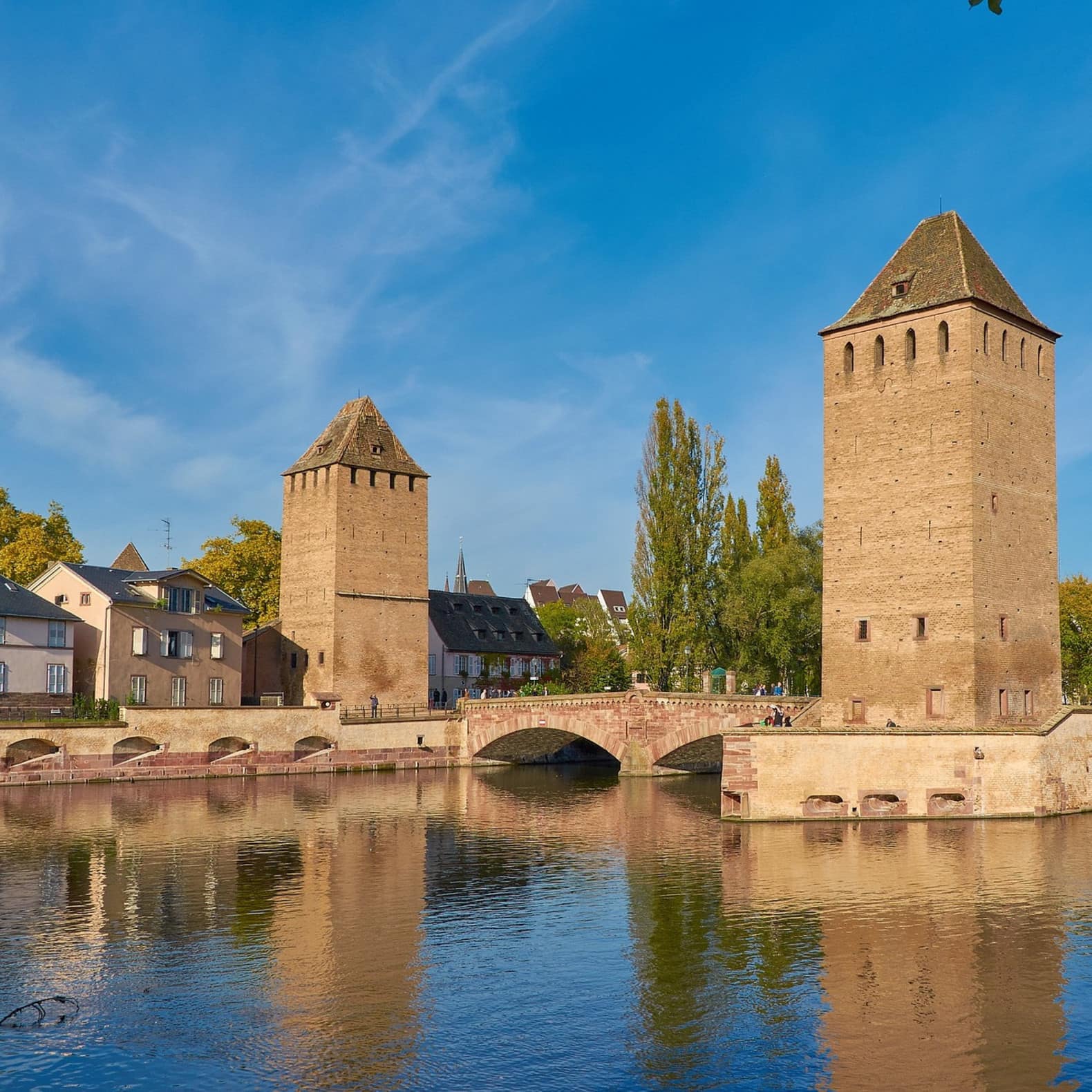 Deux tours carrées encadrent un pont de pierre, témoignant de la richesse patrimoniale de Strasbourg en Alsace