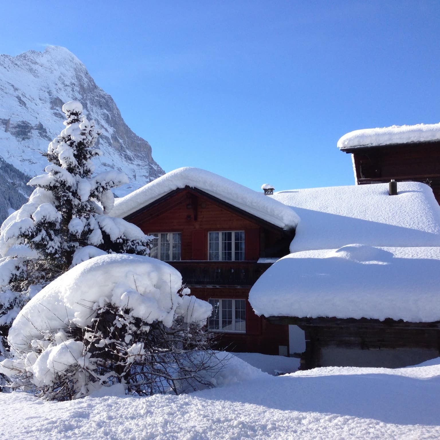 Un petit chalet en bois recouvert de neige