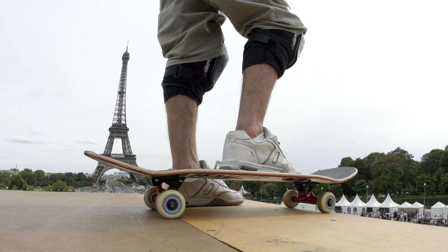 Gros plan sur un skate avec la tour Eiffel derrière