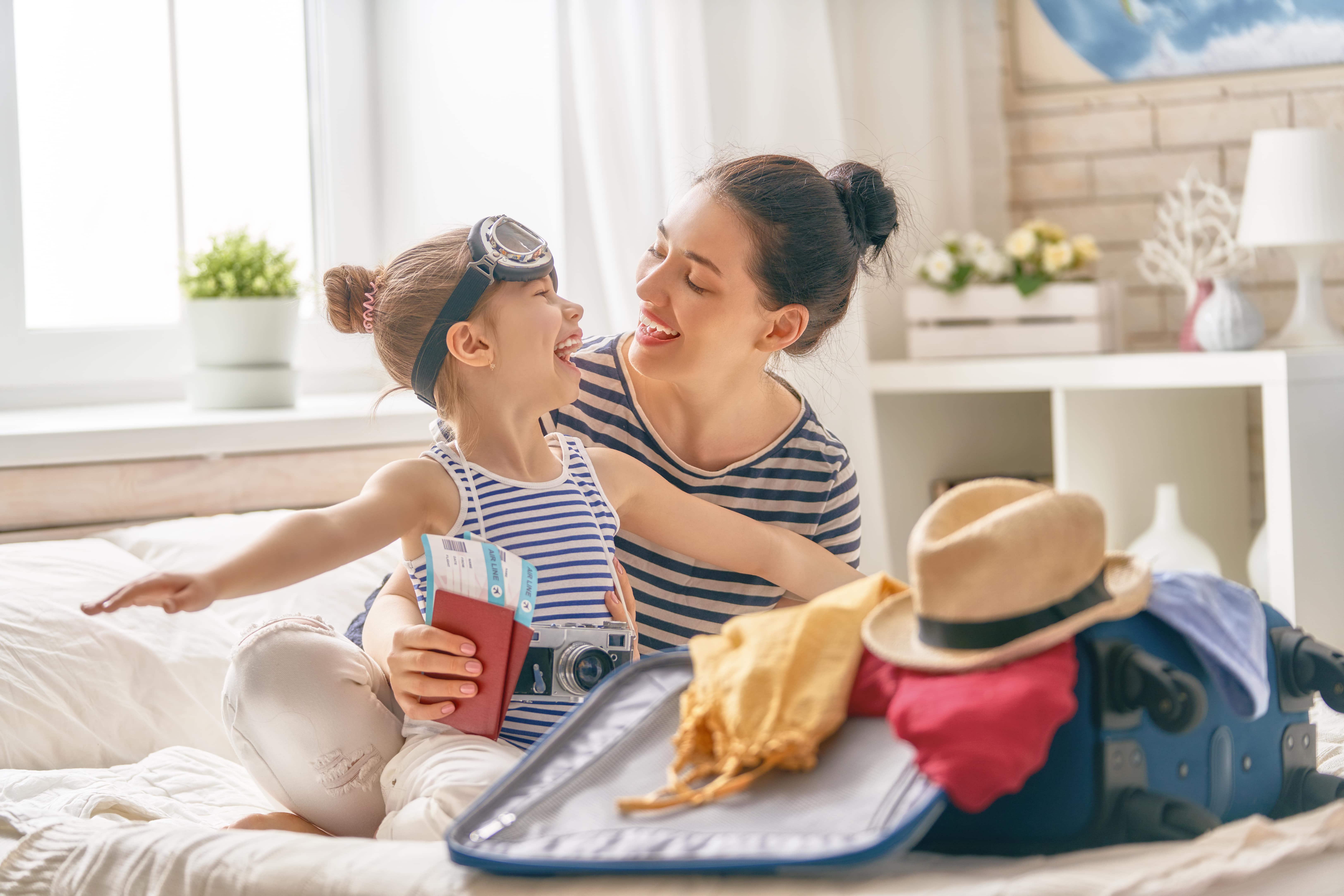 maman et fille emballant tout en tenant des passeports
