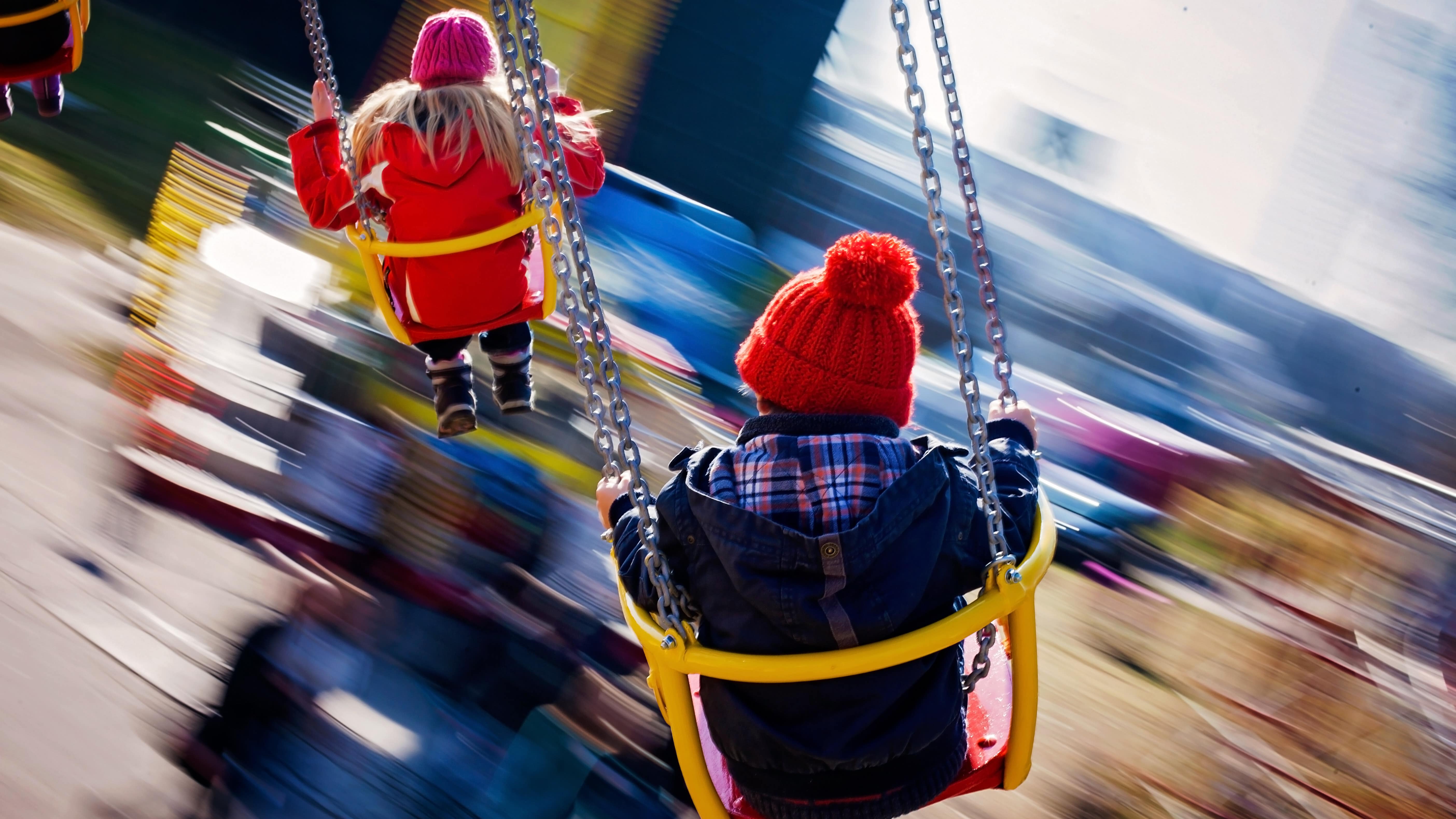 Des enfants s’amusant sur un manège de type « chaises volantes »