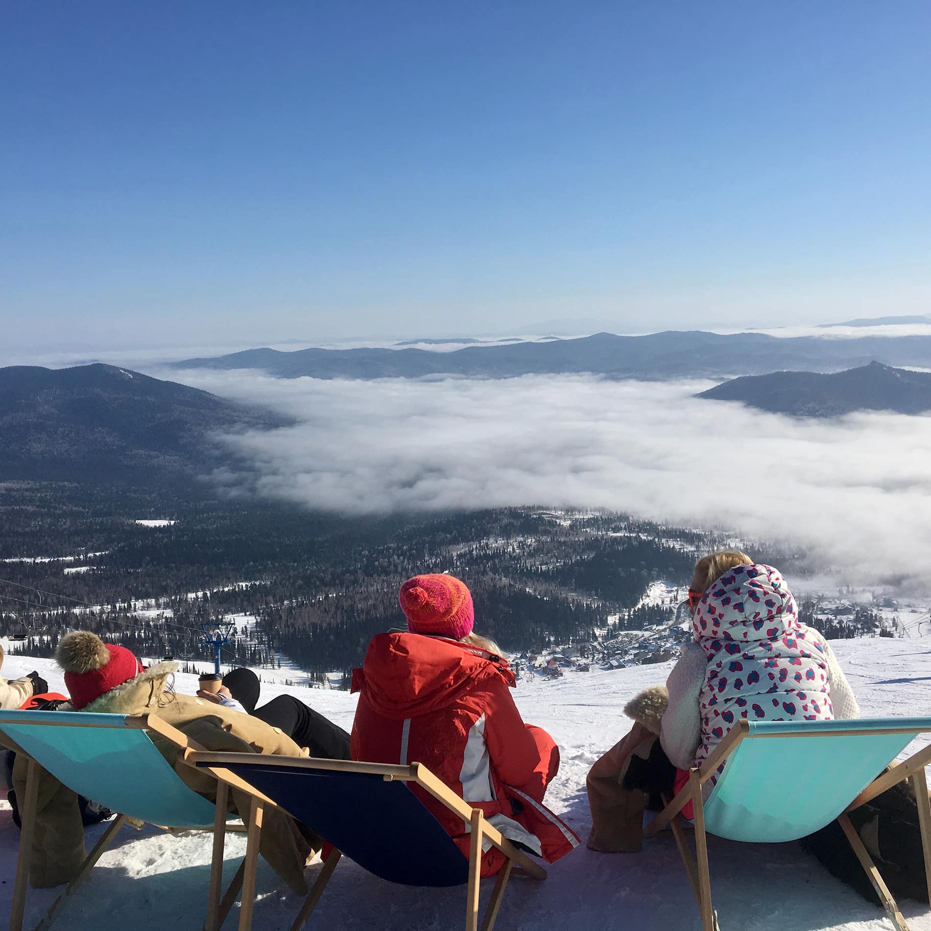 Skiers relaxing in front of mountain panorama