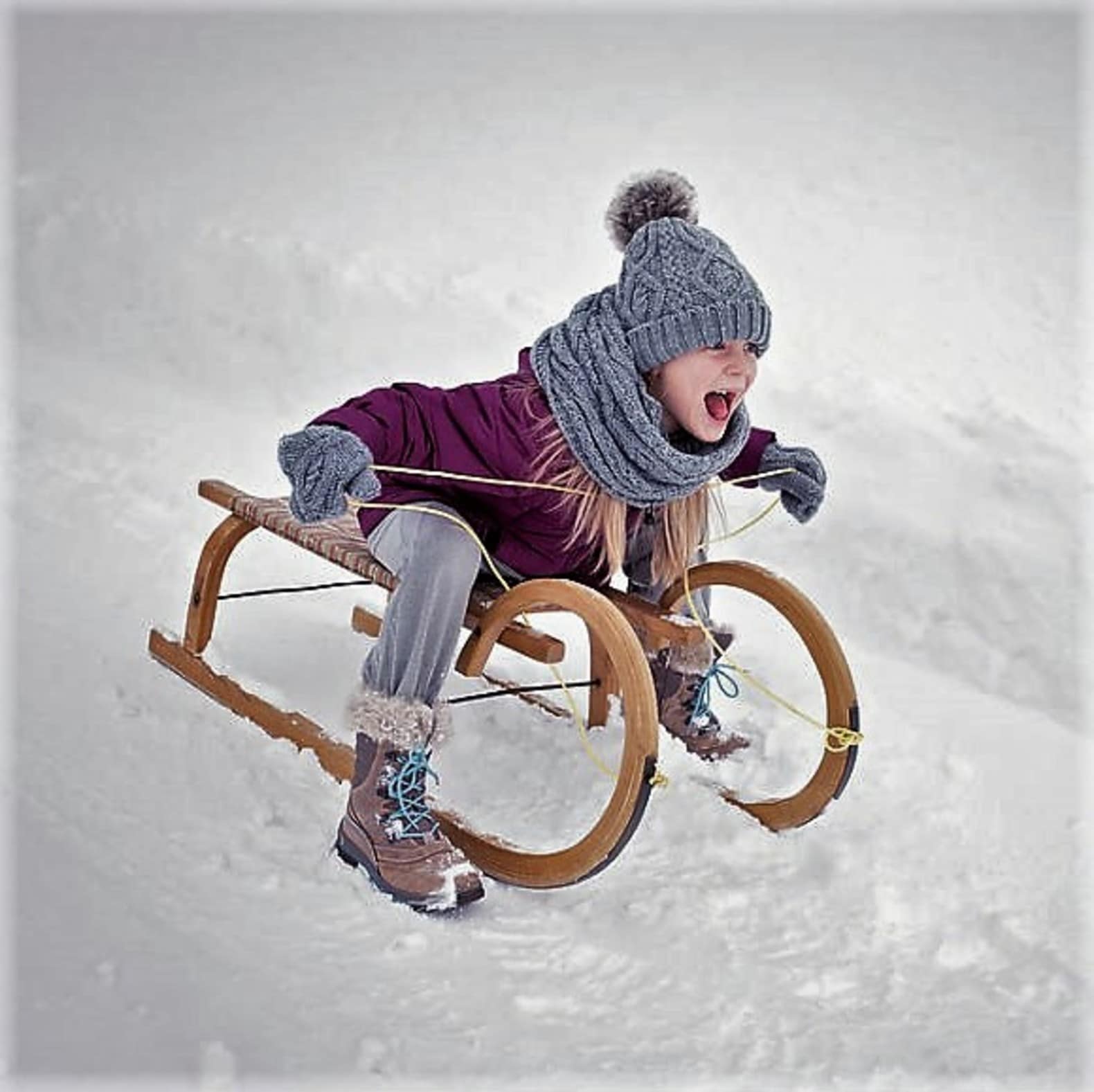 Fillette sur une luge en bois, week-end avec enfant
