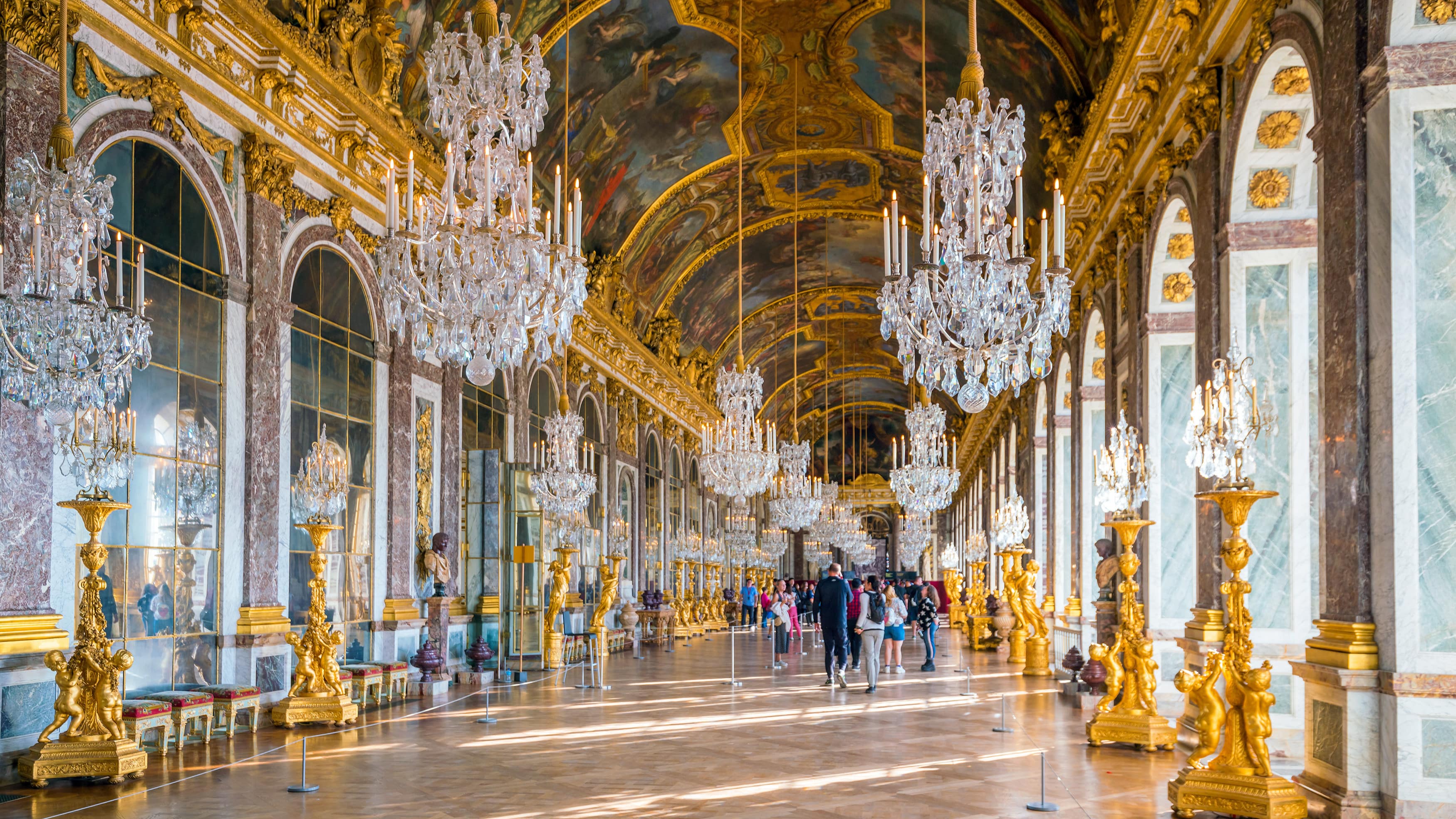 Des visiteurs admirent la galerie des Glaces au château de Versailles