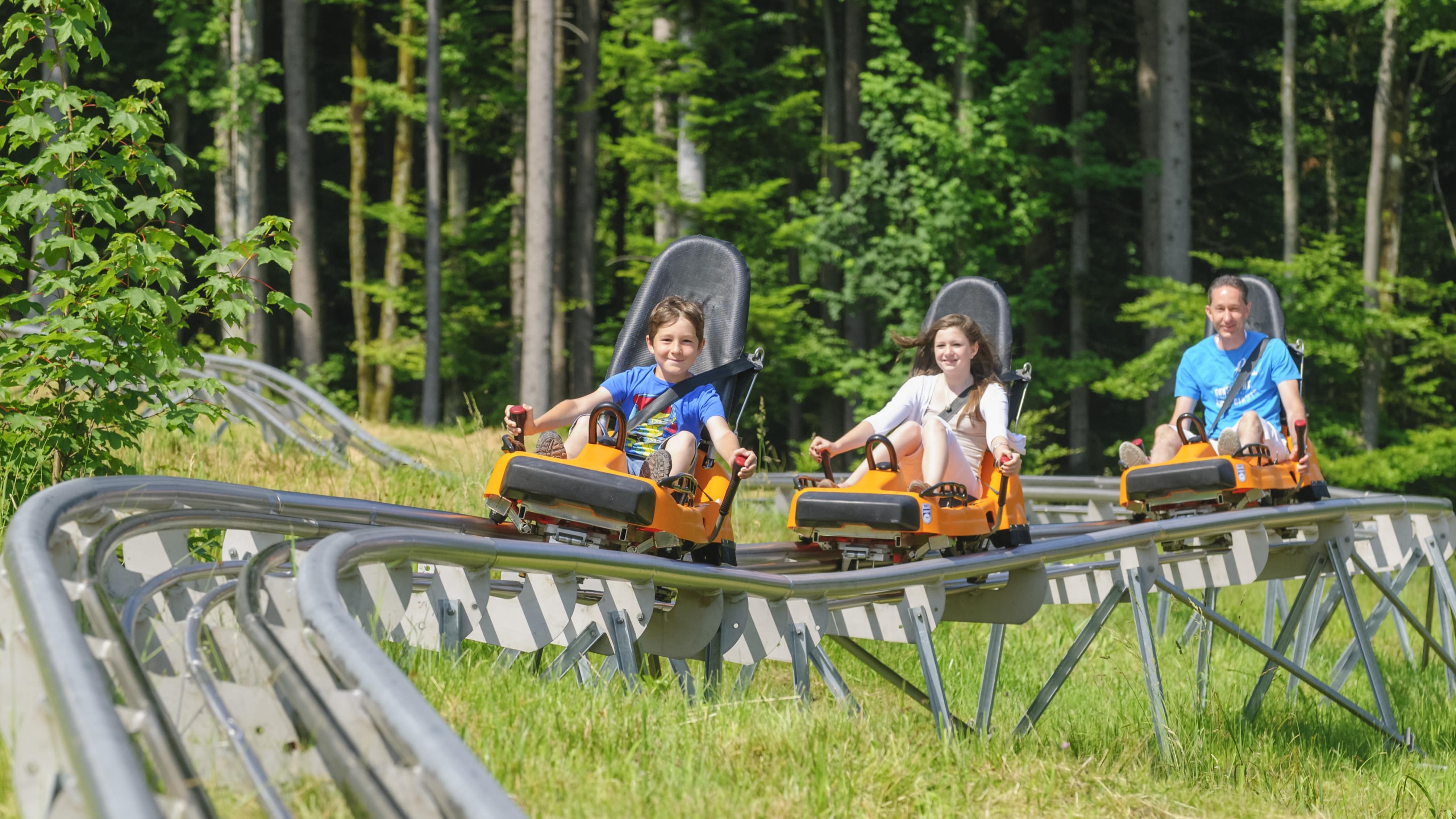 Enfants et leur père sur des luges d’été