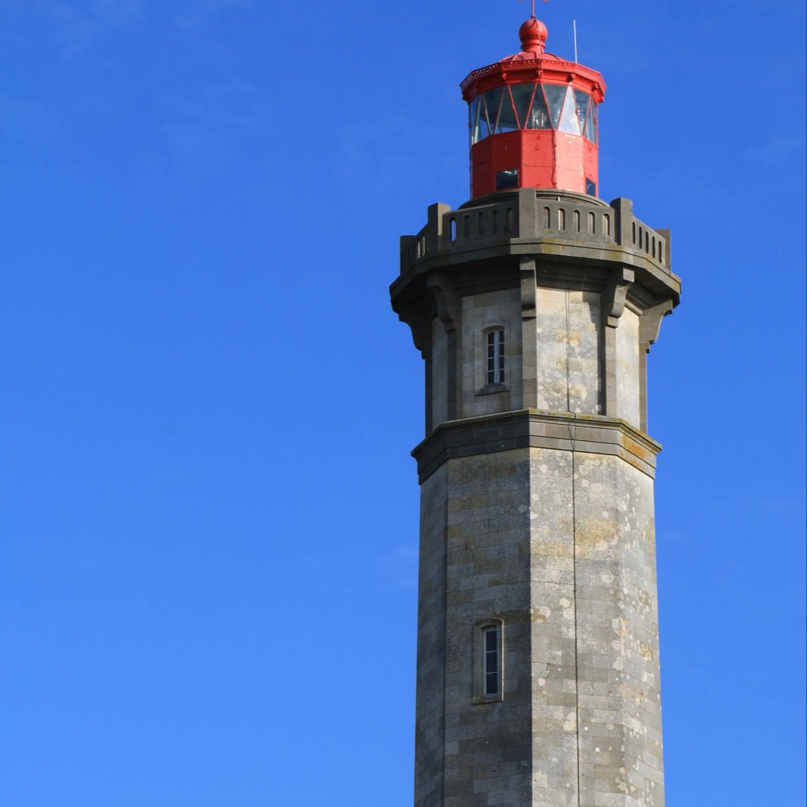Un phare au toit rouge sur fond de ciel bleu. Bienvenue sur l'île de Ré