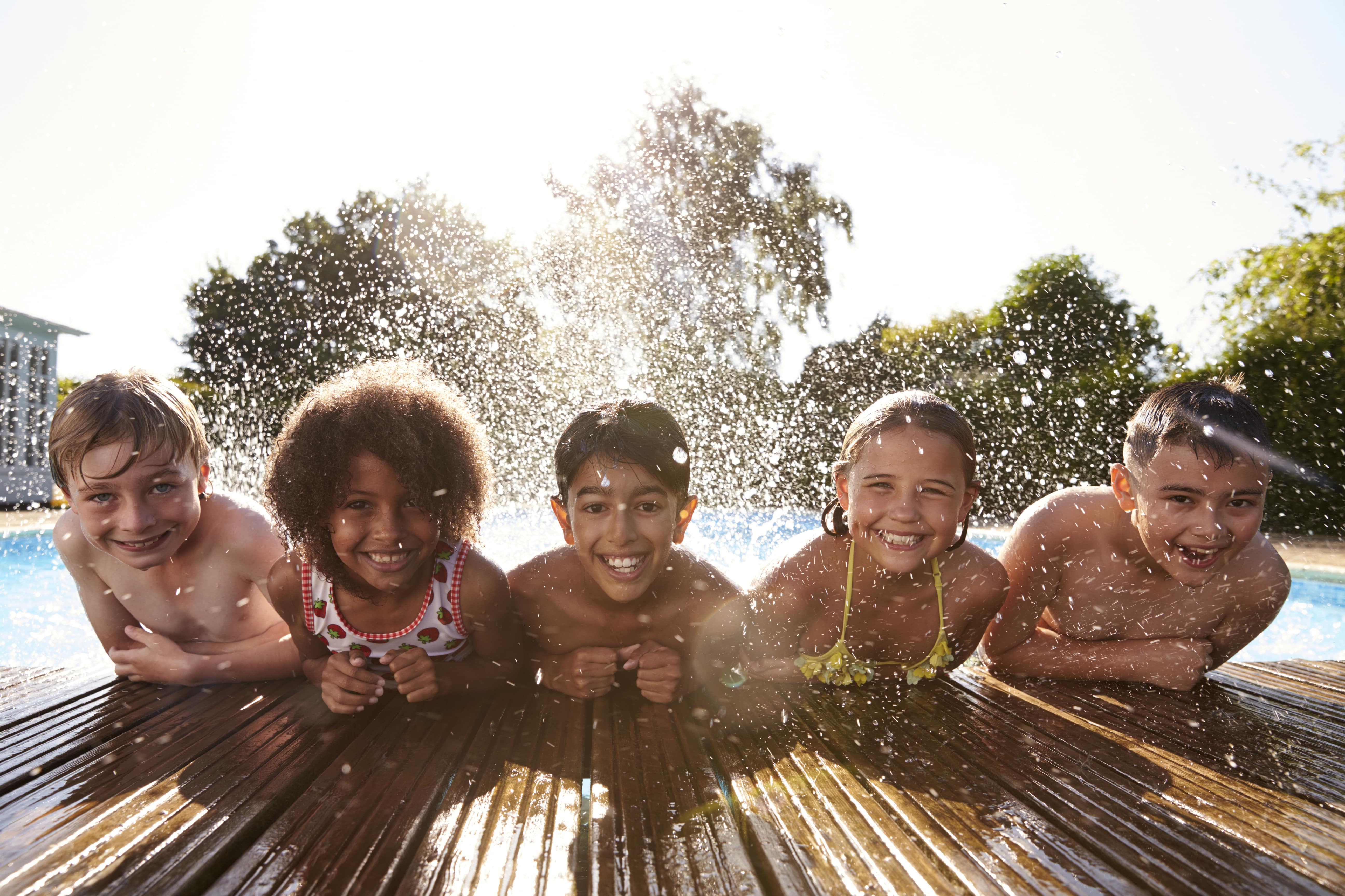 enfants souriant au bord d'une piscine