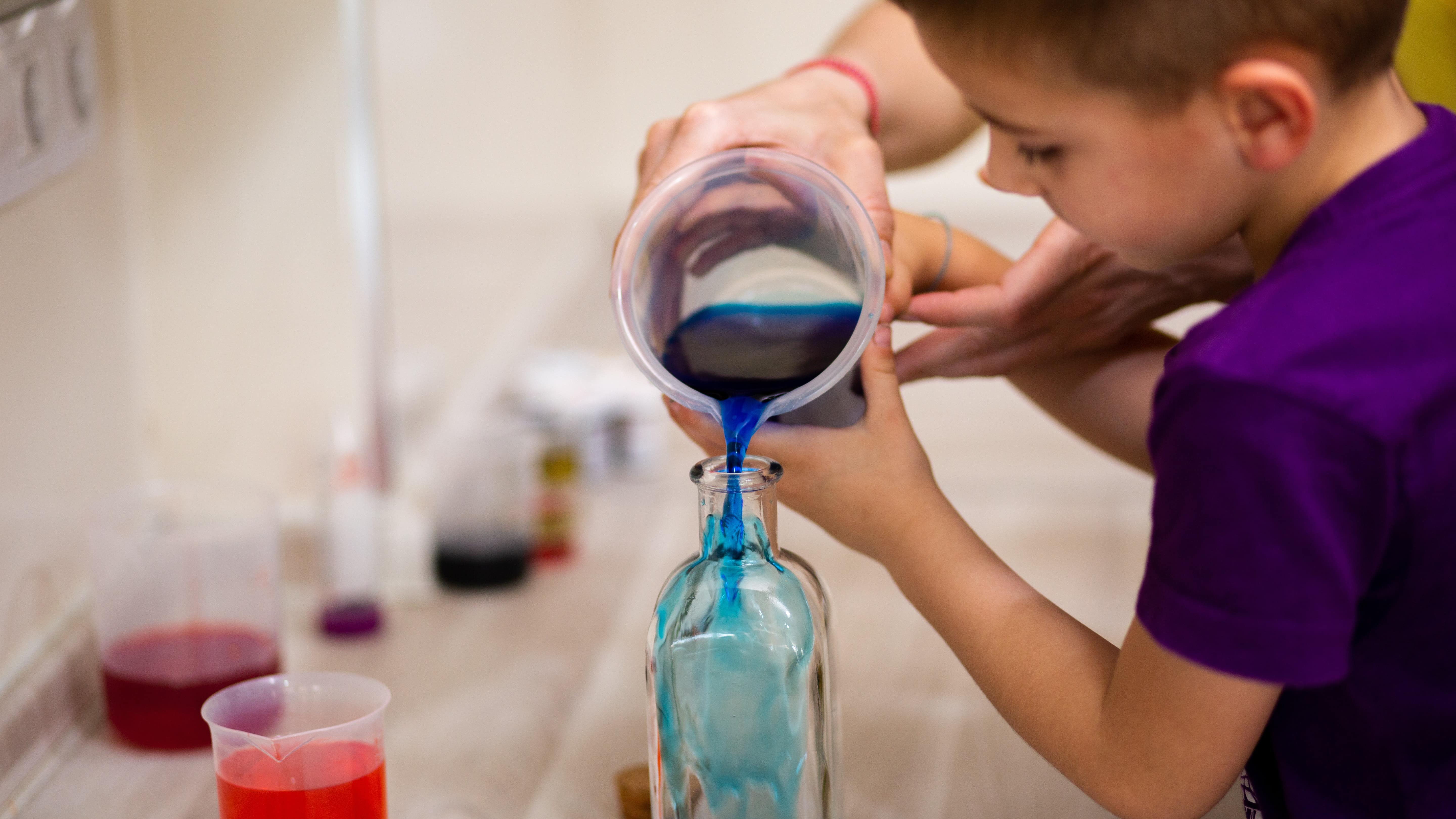 Enfant réalisant une expérience avec des liquides colorés