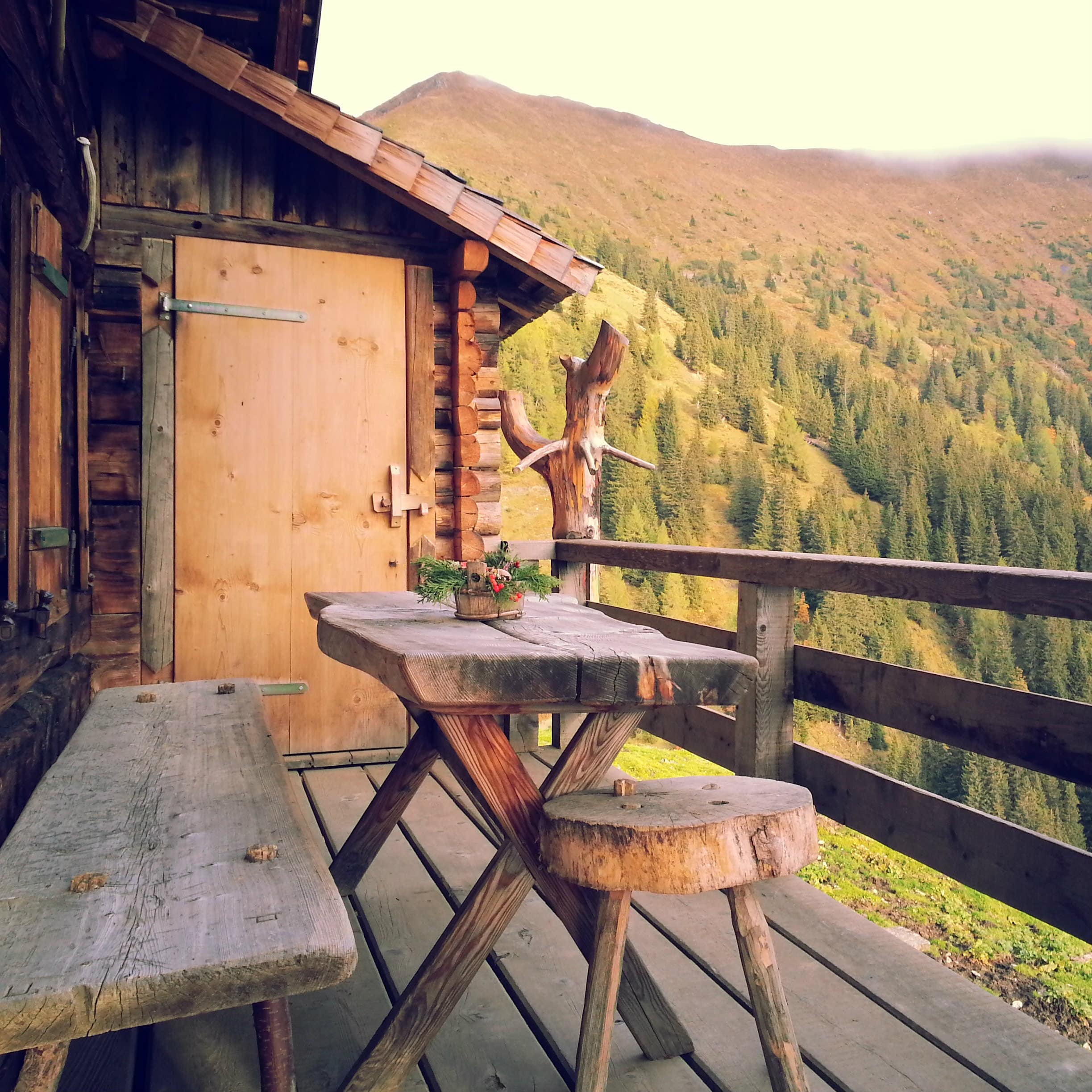 Des bancs en bois sur le balcon d'un chalet de montagne en journée