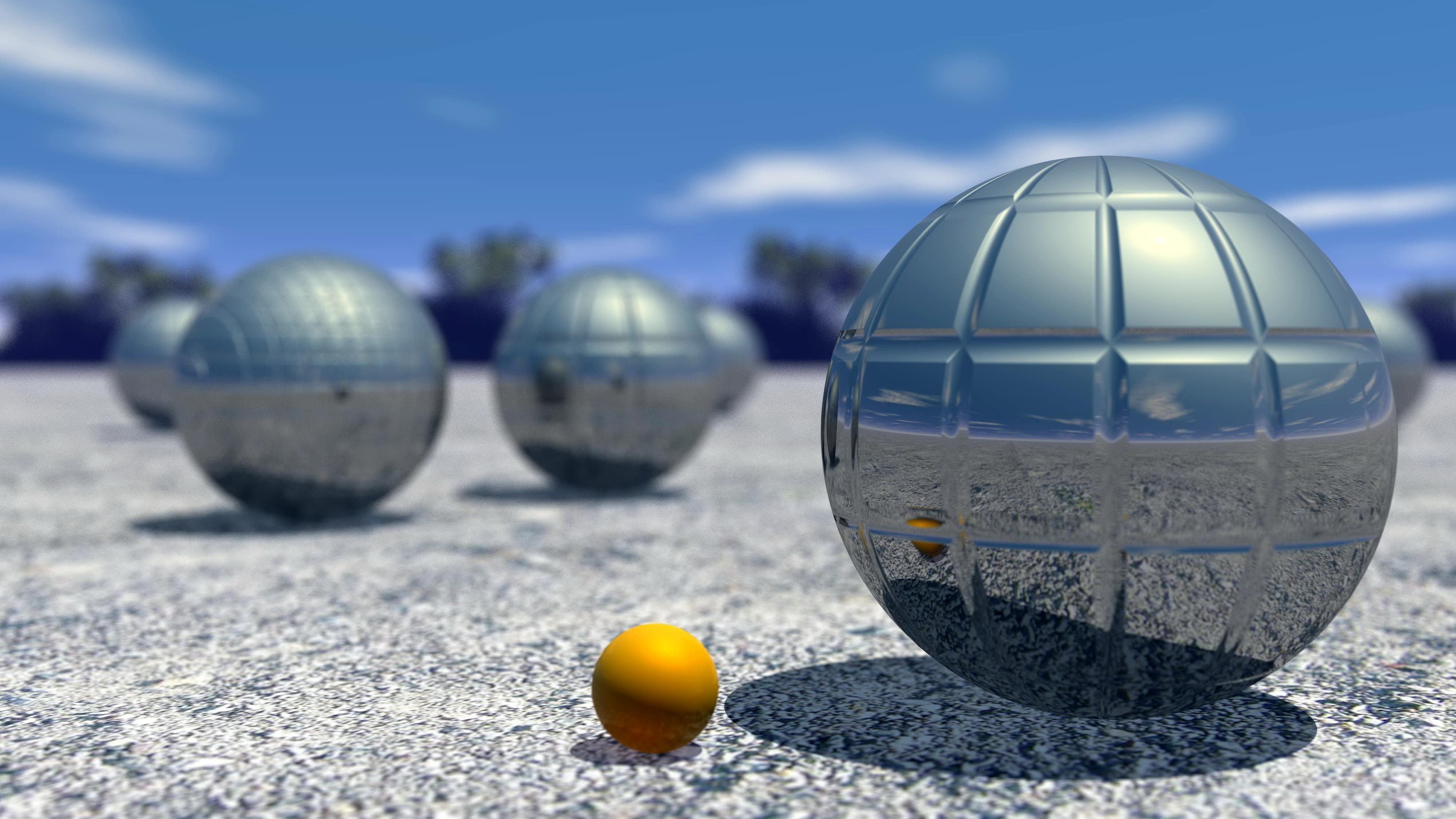 Gros plan sur des boules de pétanque qui luisent au soleil et un cochonnet