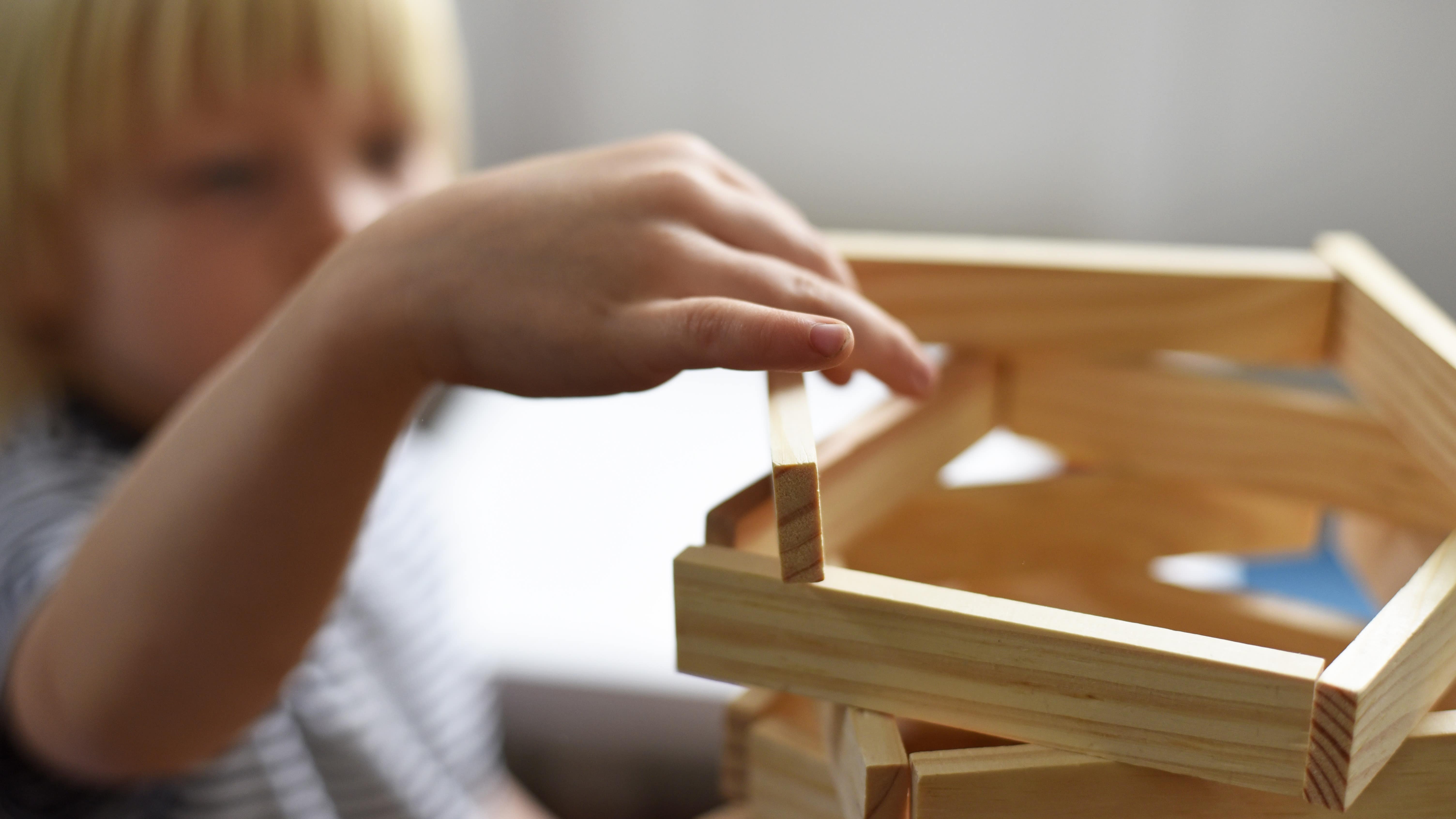 Enfant construisant une tour en planchettes Kapla