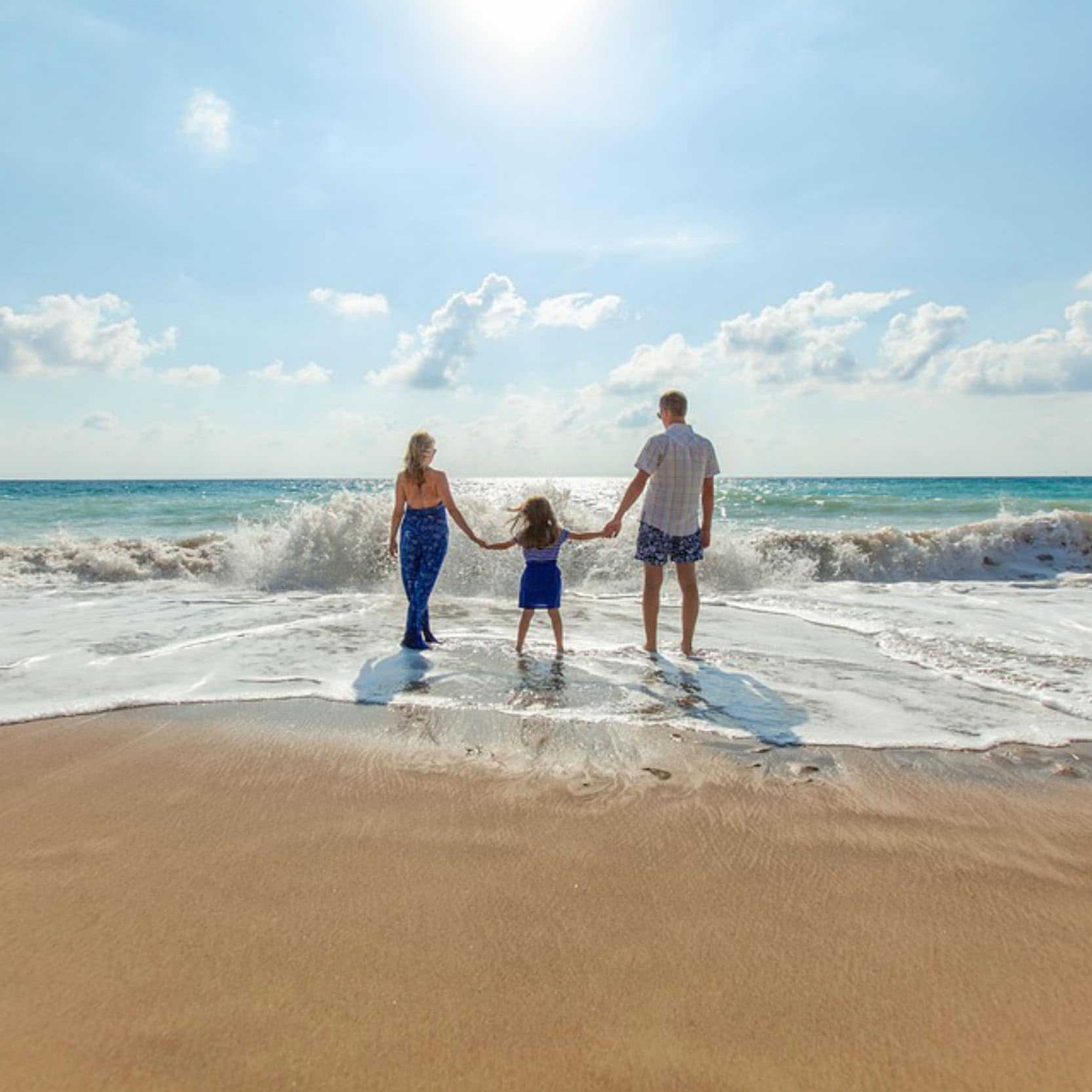 Couple avec un enfant sur la plage, vagues, week-end sympa en famille
