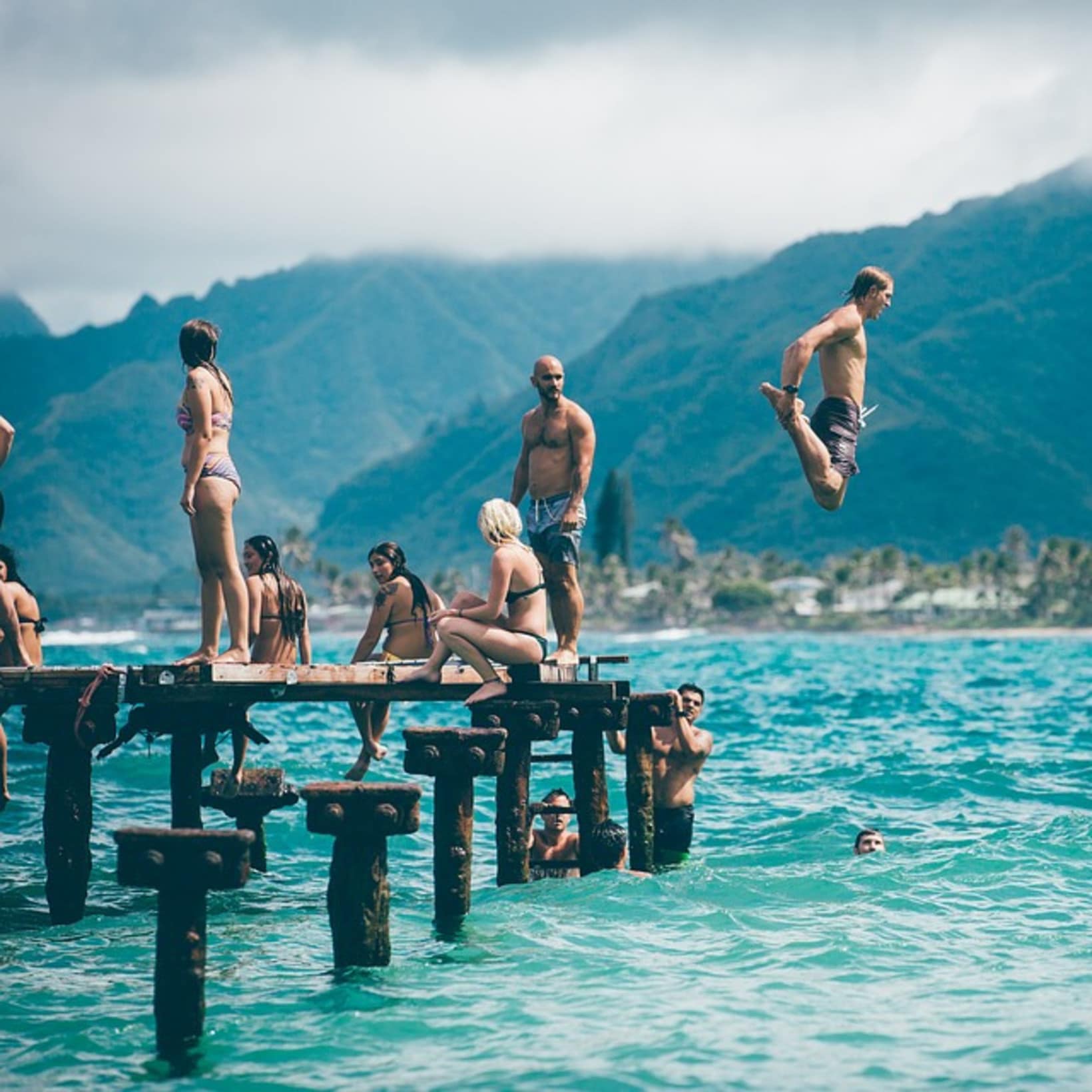 Personnes sur un ponton, homme sautant dans l’eau, vacances pas cher en famille en aout