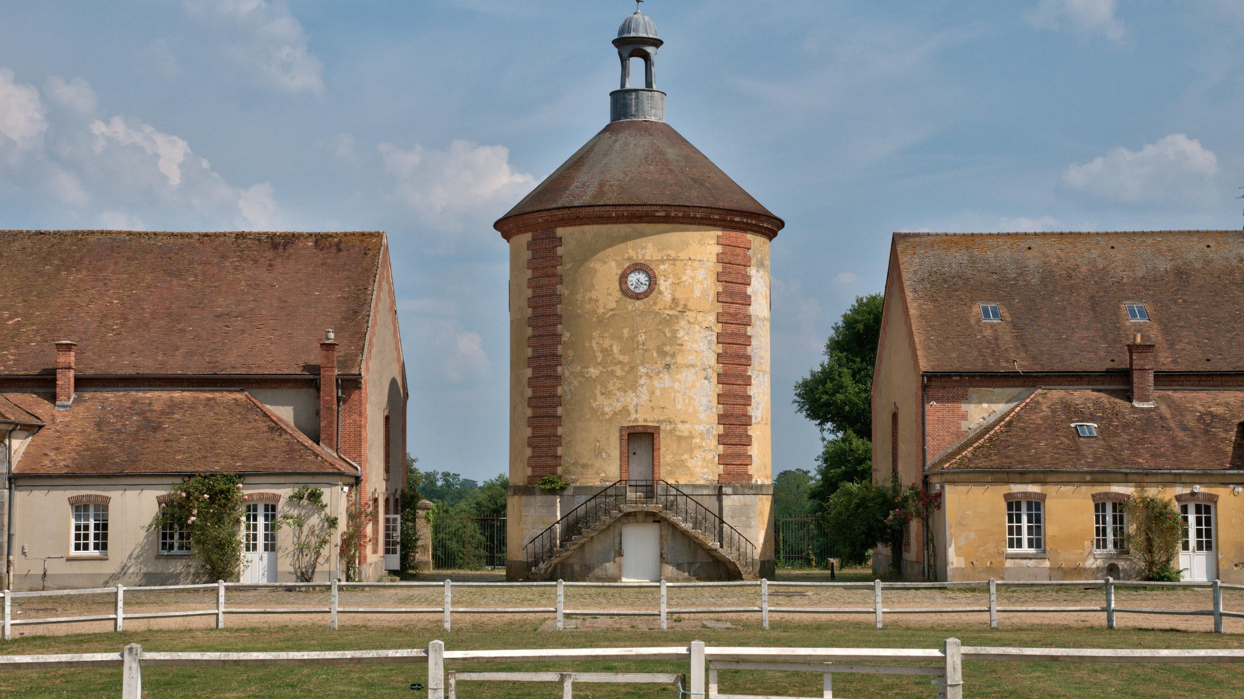 Un enclos et des bâtiments anciens de la bergerie de Rambouillet